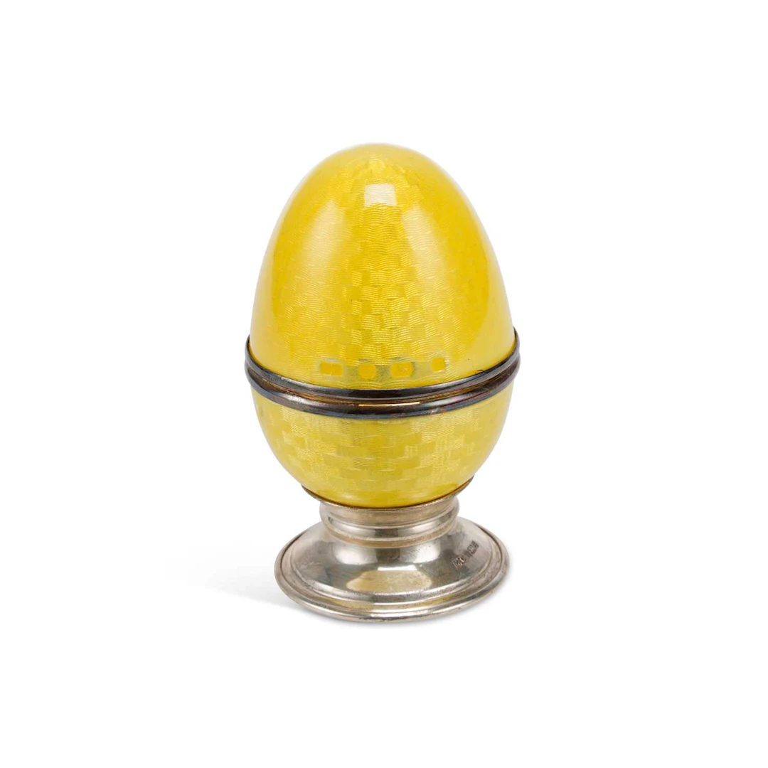 AN ELIZABETH II SILVER AND ENAMEL EGG ON STAND
