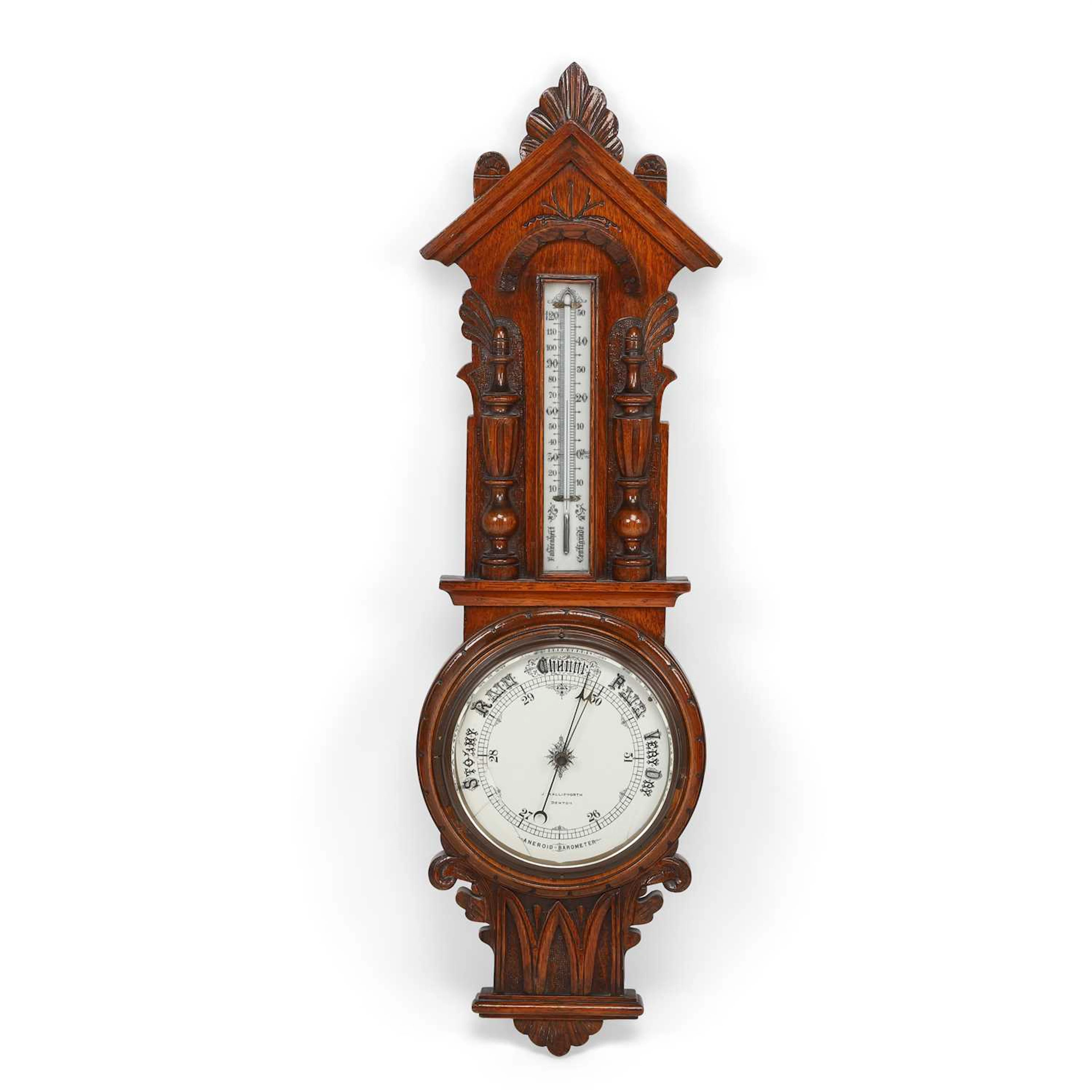 A CARVED OAK ANEROID BAROMETER