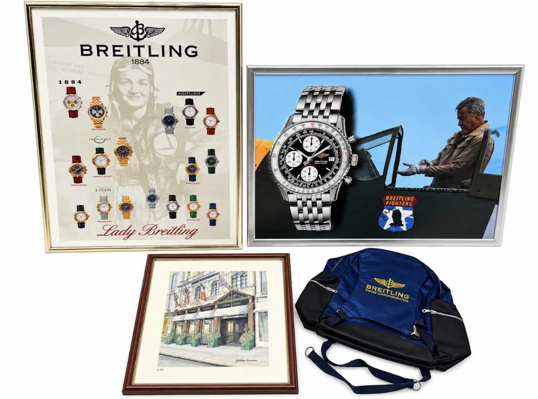 A BREITLING RUCKSACK, TWO BREITLING FRAMED PRINTS AND A CARTIER FRAMED PRINT