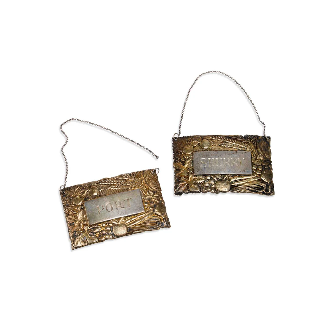 A PAIR OF ELIZABETH II PARCEL-GILT SILVER WINE LABELS
