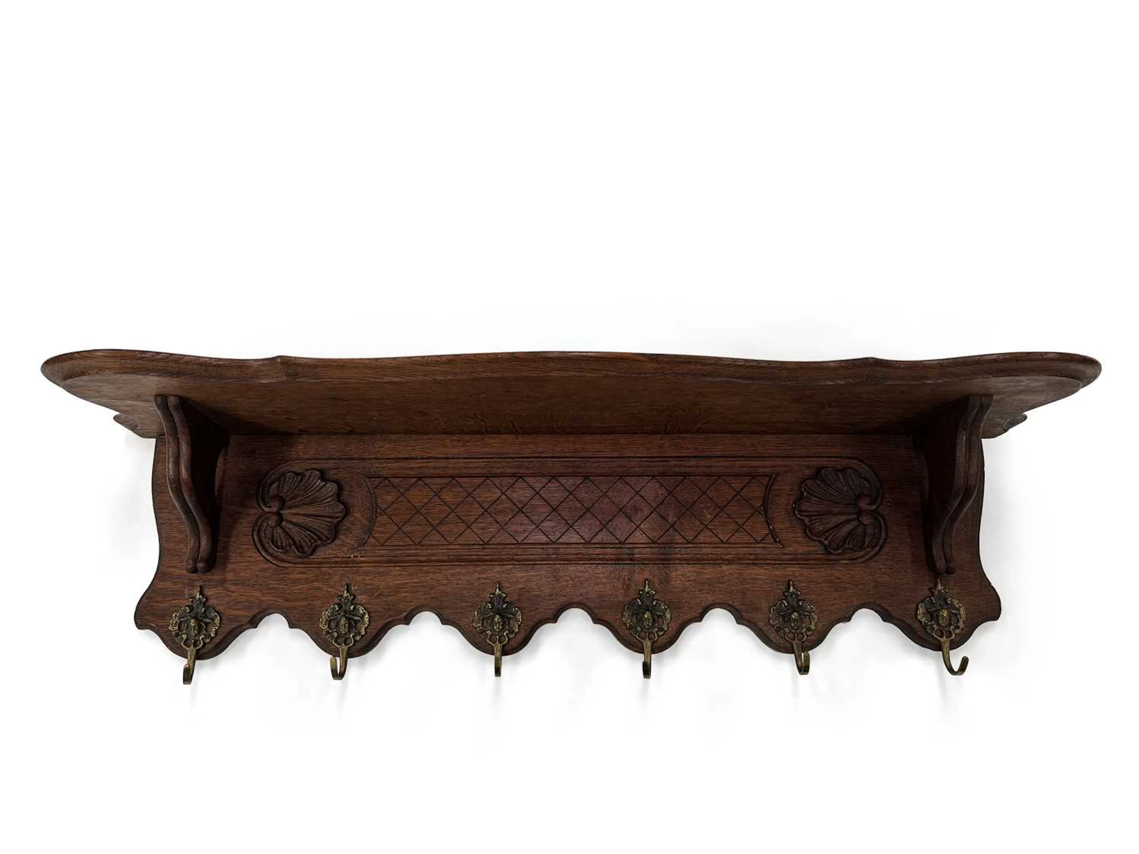 A CARVED OAK WALL SHELF AND COAT RACK