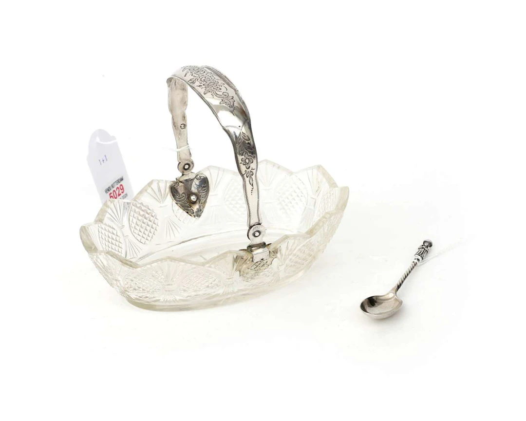A crystal bonbonniere with a sterling silver handle and a sterling
