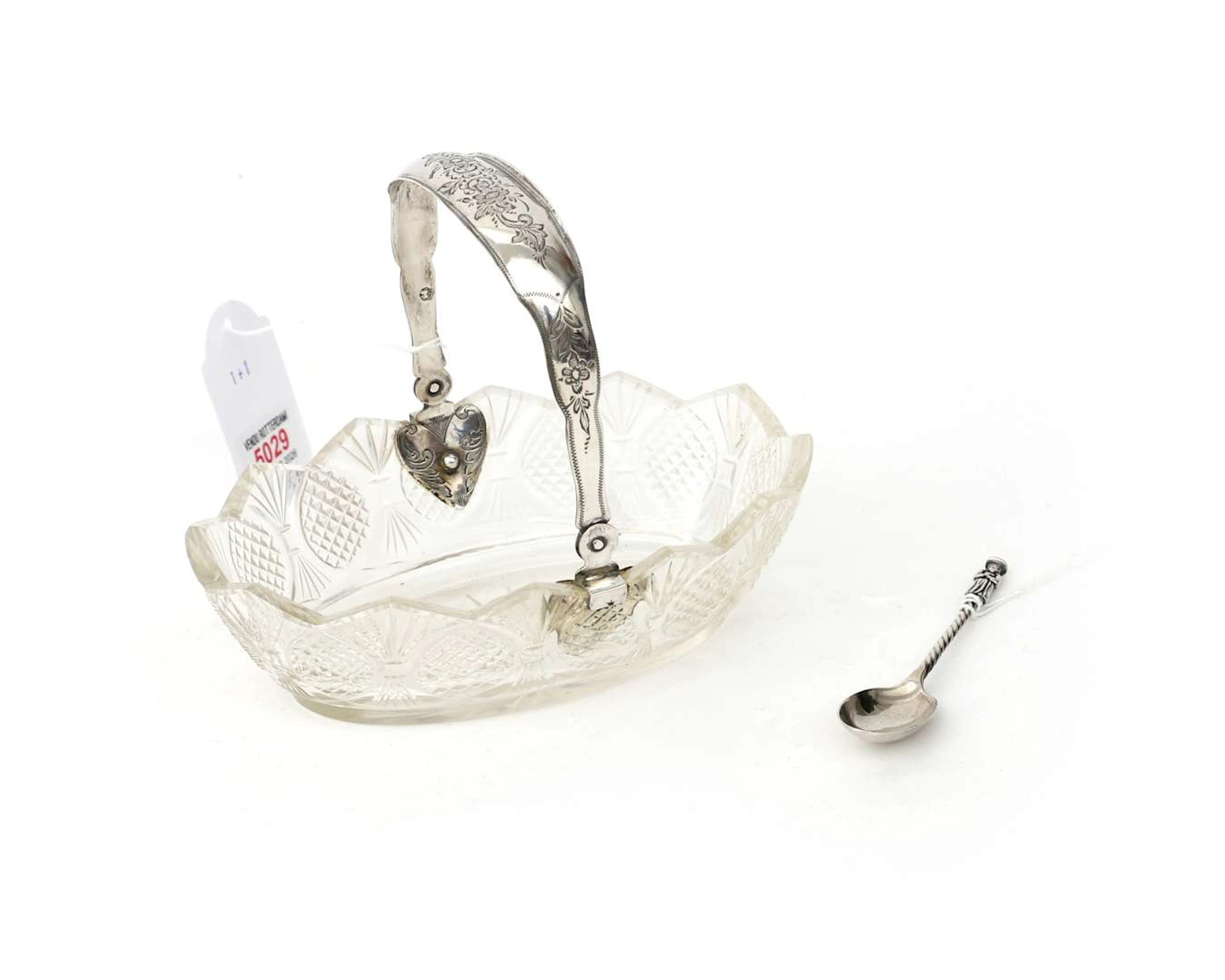 A crystal bonbonniere with a sterling silver handle and a sterling