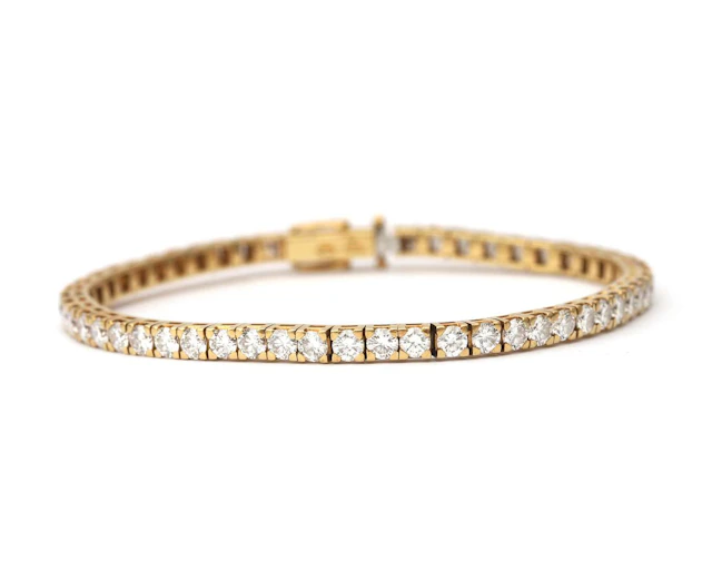 An 18k yellow gold tennis bracelet set with approx. 5.94 ct. of diamonds