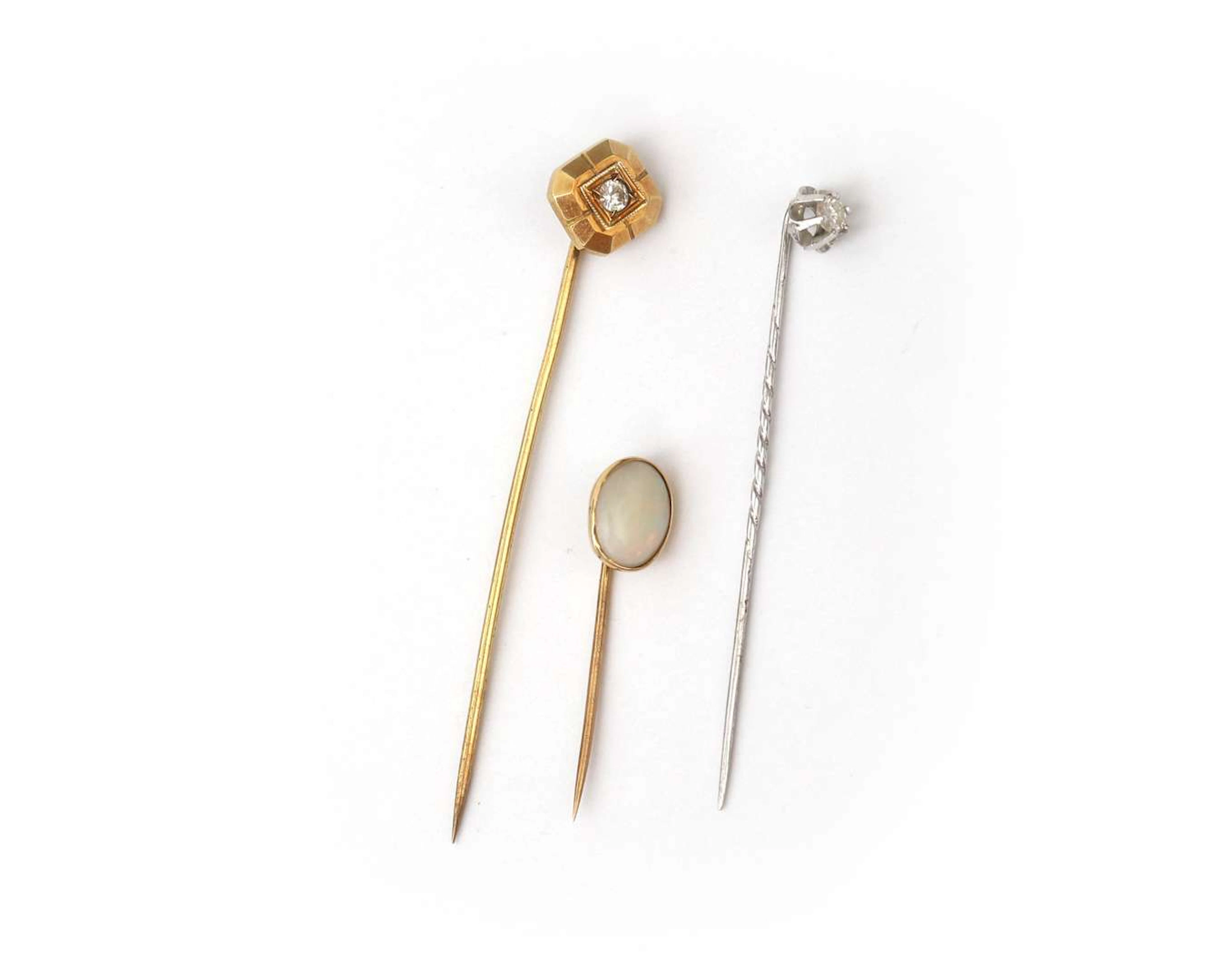 A set containing three gold lapel pins