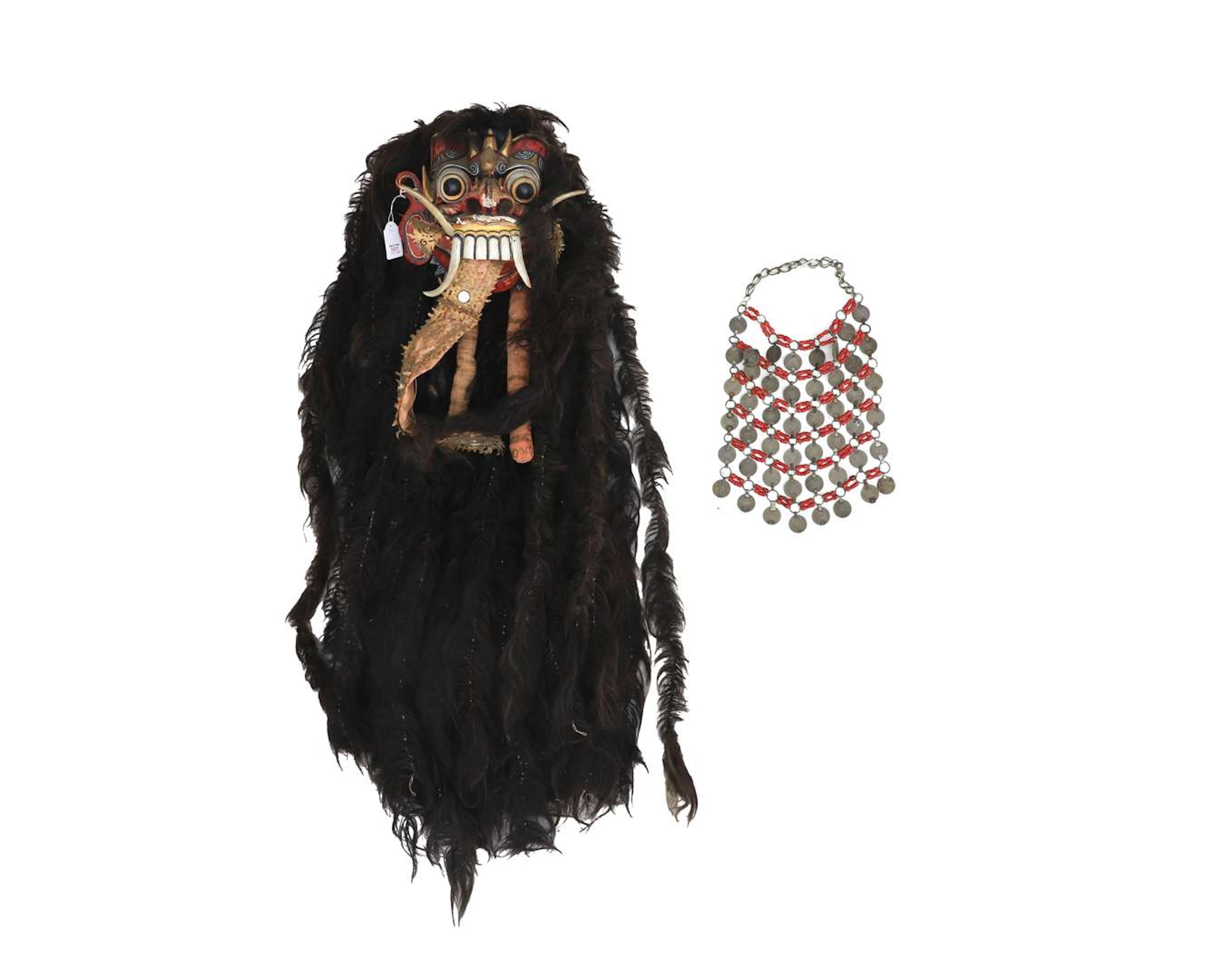 A Balinese mask, possibly Rangda, and a coin necklace (2)
