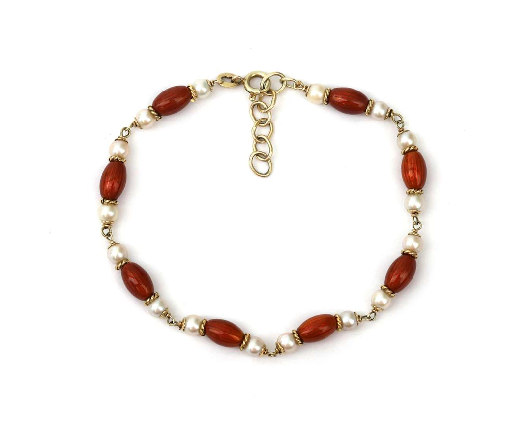 A 14k yellow gold bracelet with cultivé pearls and orange-red enamel