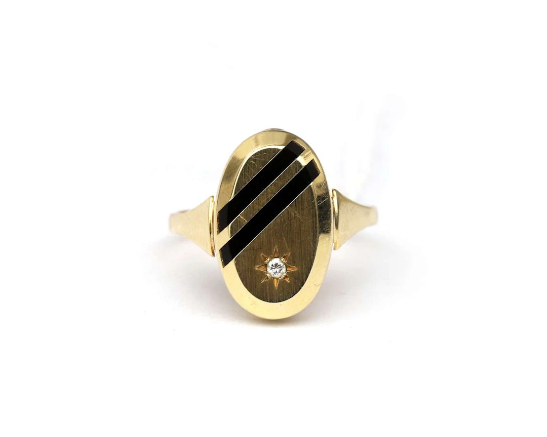 A 14-carat yellow gold ring with onyx and a diamond