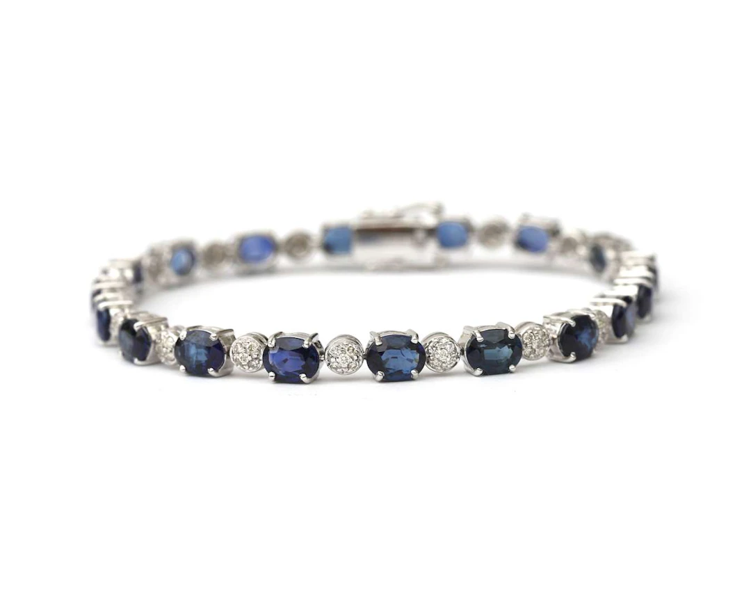 An 18k white gold tennis bracelet set with sapphires and diamonds
