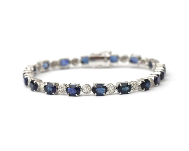 An 18k white gold tennis bracelet set with sapphires and diamonds