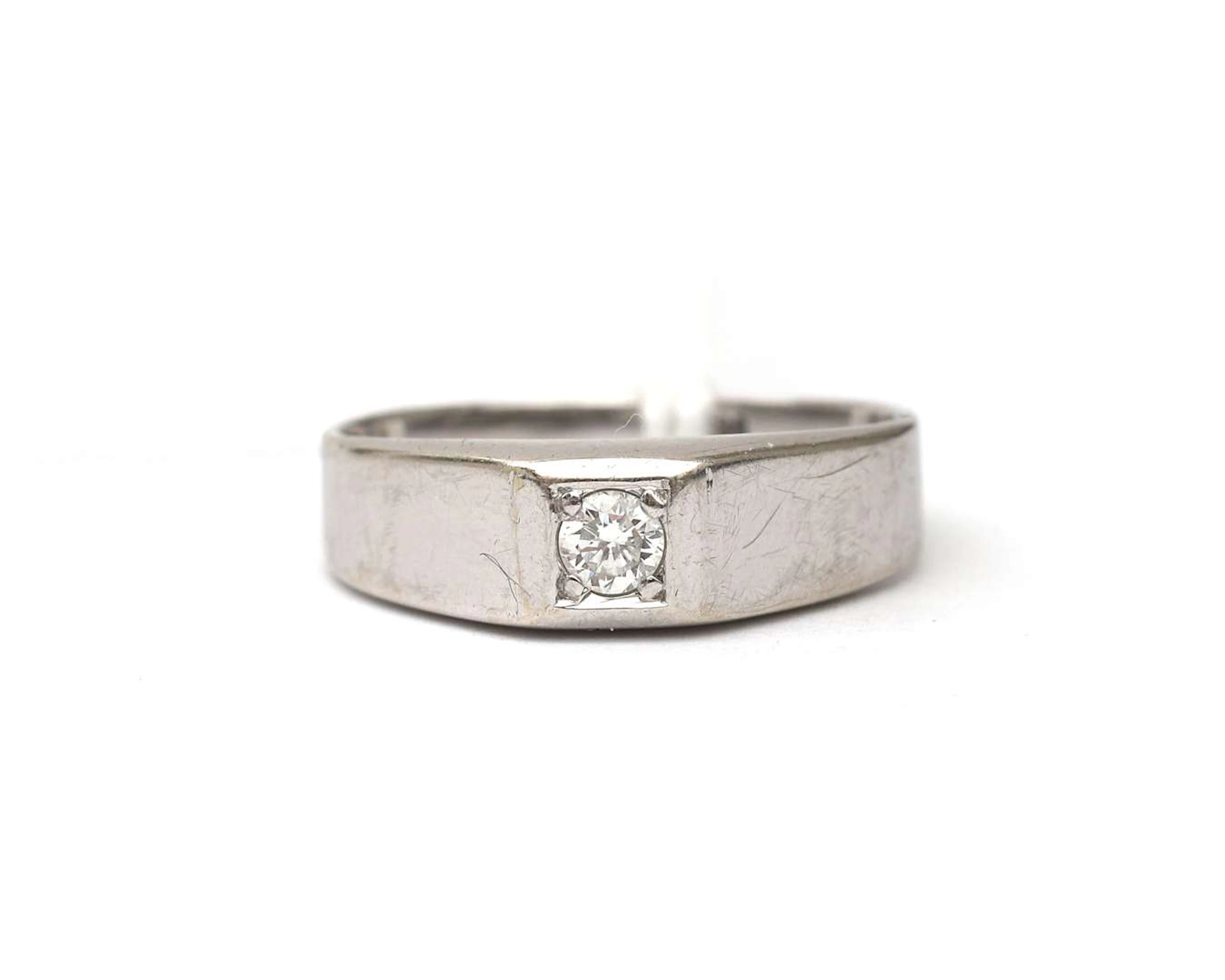 A 14k white gold little finger ring set with a diamond