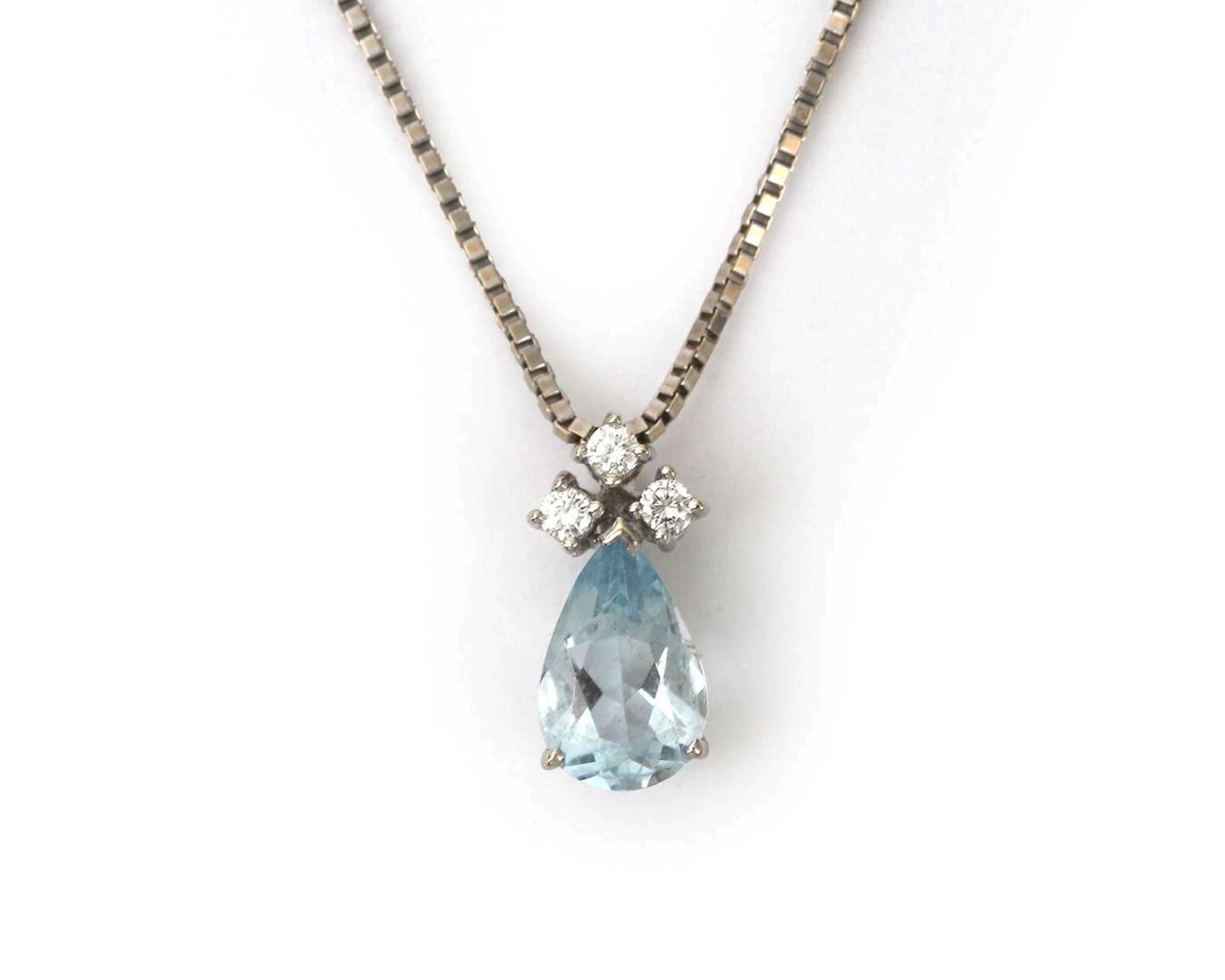 A 14k white gold necklace with a pendant featuring an aquamarine and a diamond