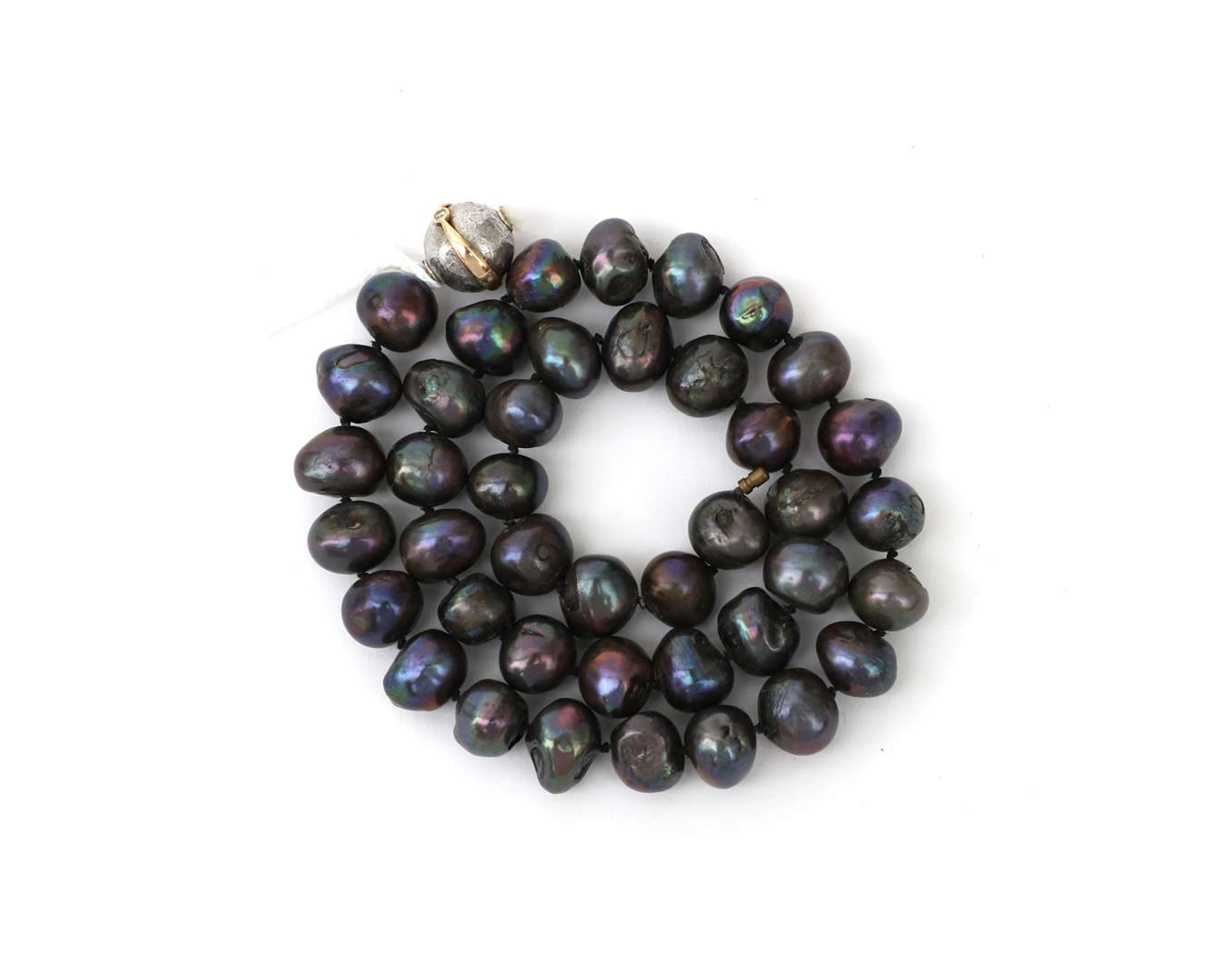 A necklace of freshwater pearls with a silver and 14k yellow gold clasp