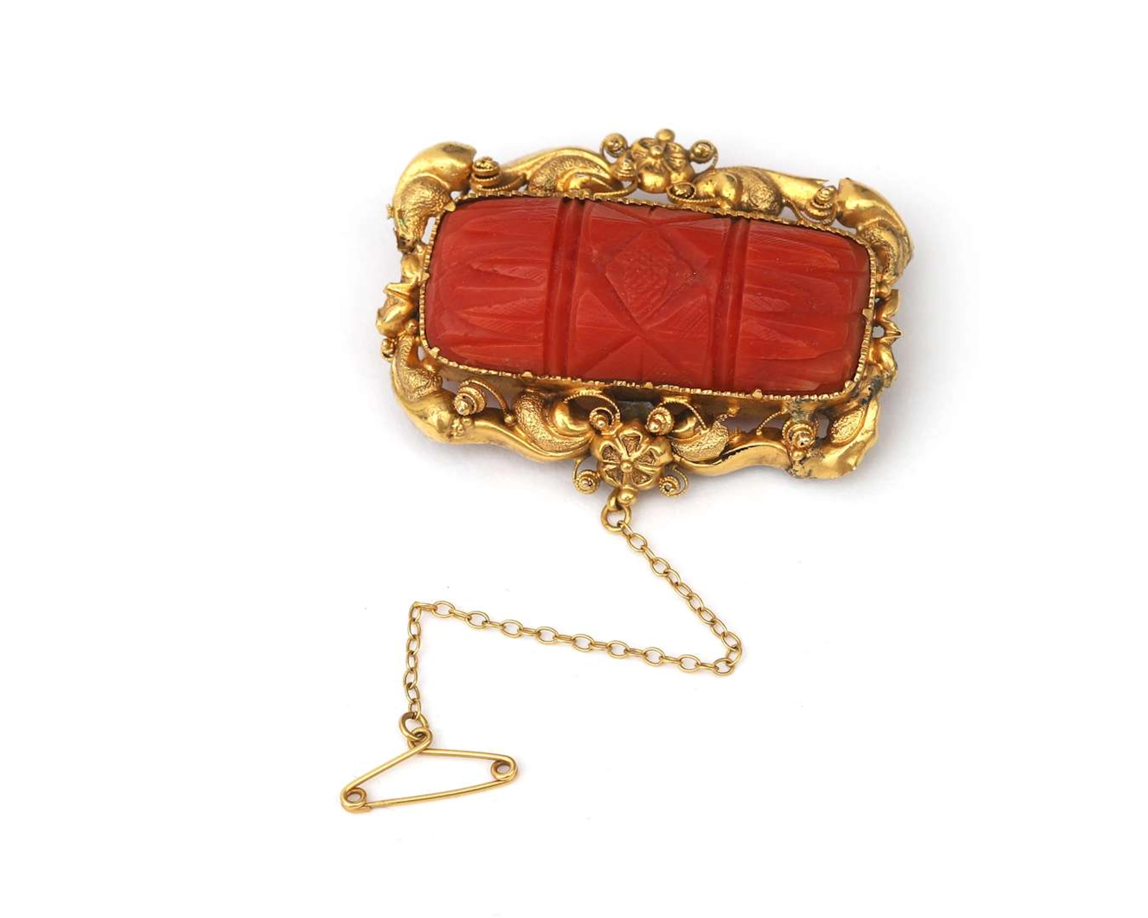 An 18k yellow gold brooch with carved coral