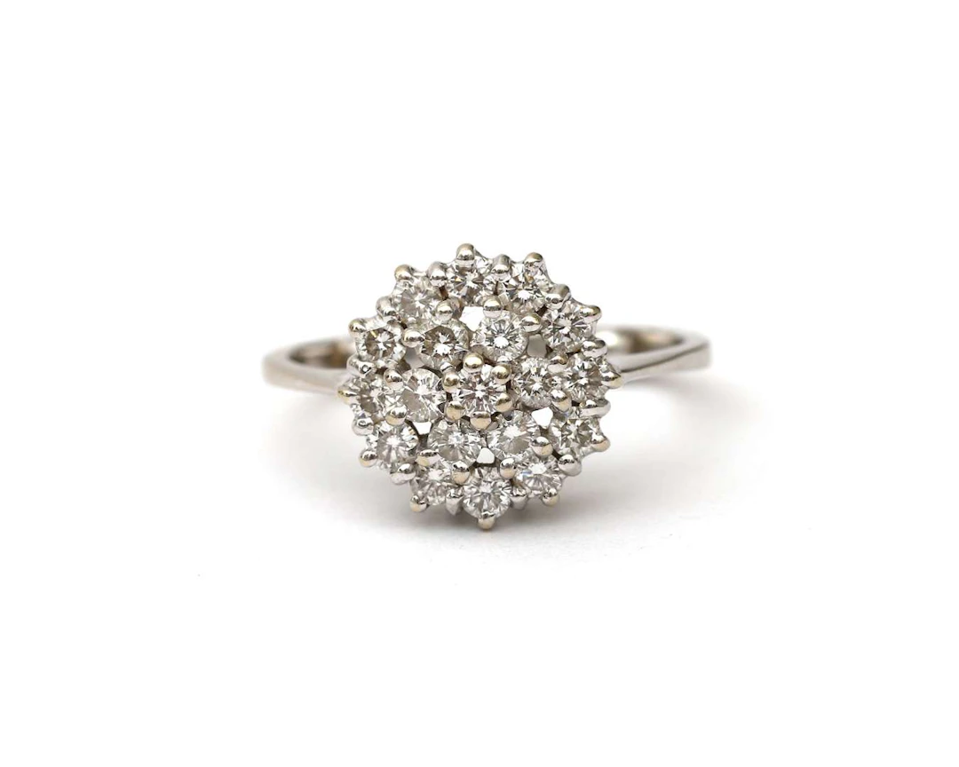 A 14k white gold rosette ring with a diamond