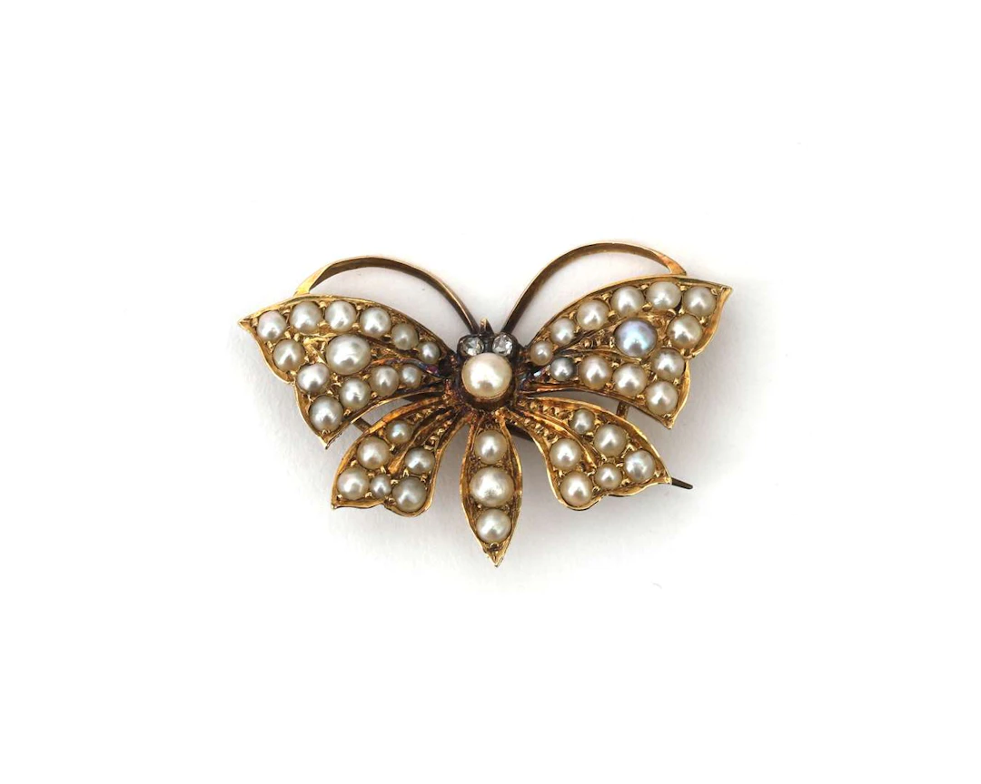A 14k yellow gold Victorian butterfly brooch with a seed pearl and