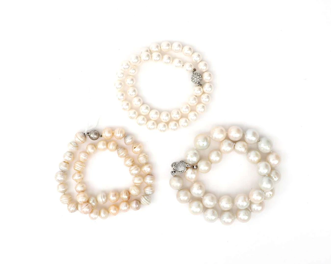 Three cultured pearl necklaces, one of which features a 14-carat white