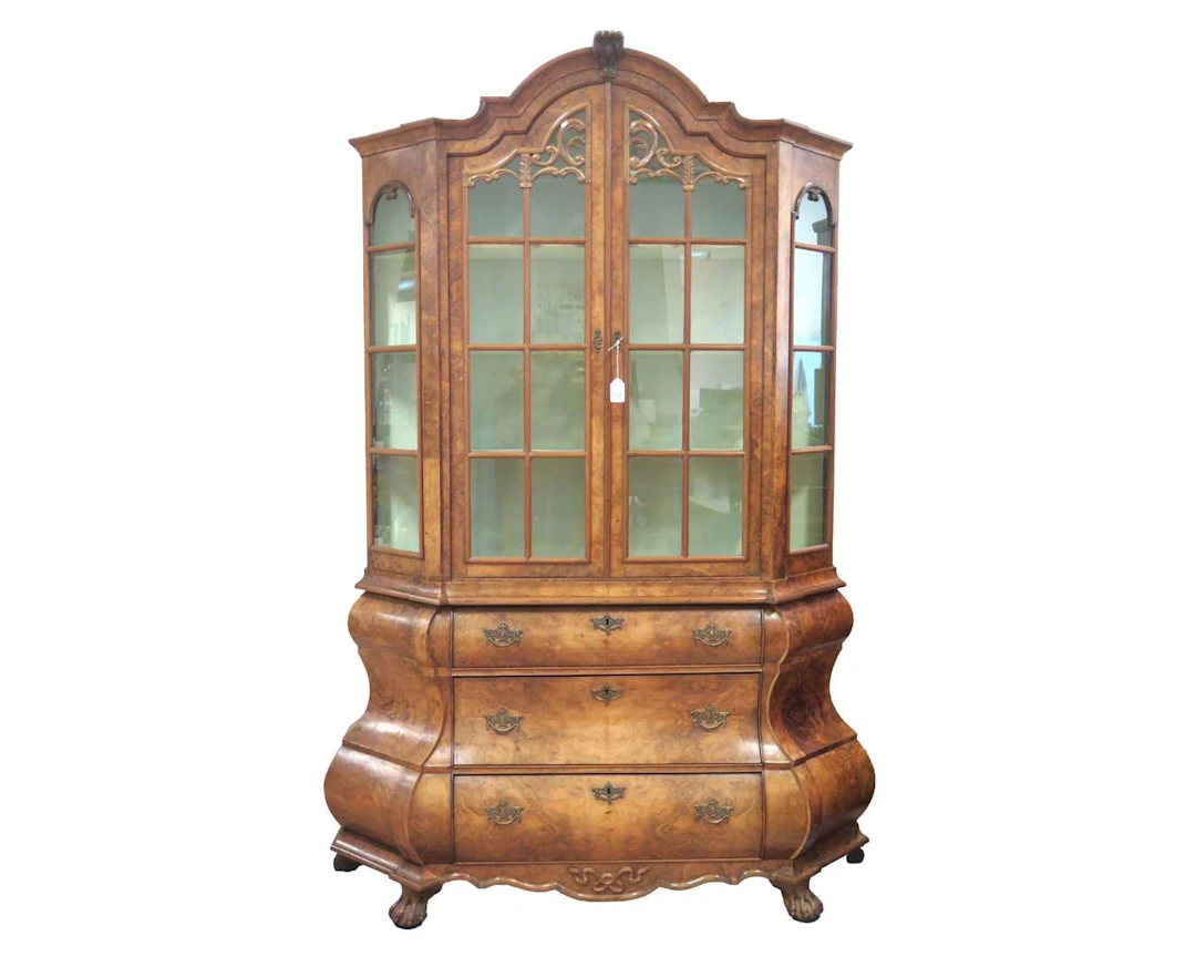 A walnut display cabinet with a crest and claw feet. 20th century