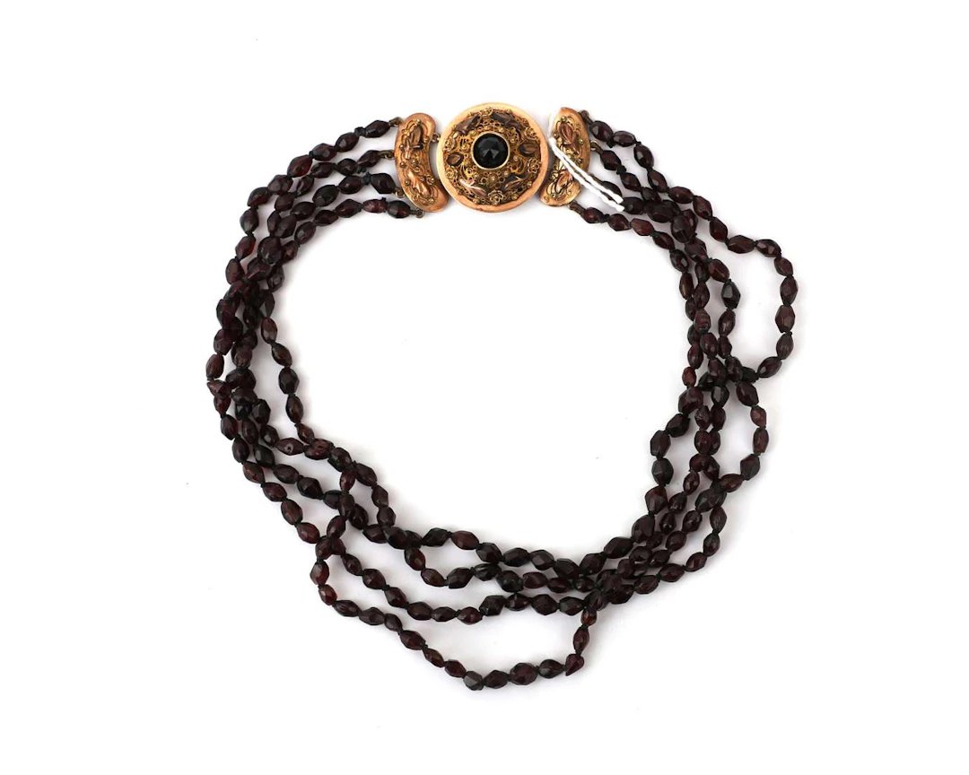 A four-strand garnet choker necklace with a 14k yellow gold clasp