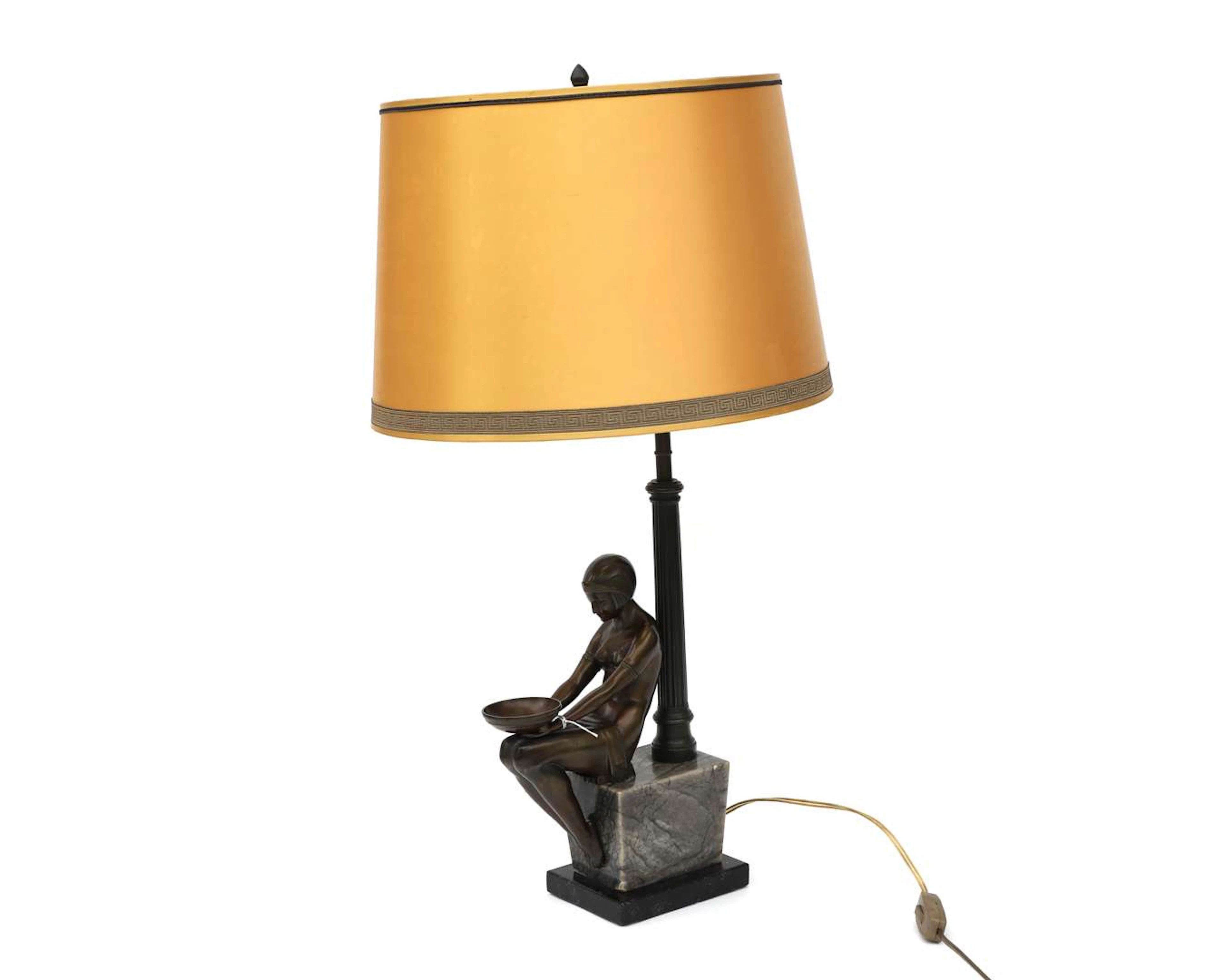 A bronze-coloured metal table lamp on a marble base. Art Deco style