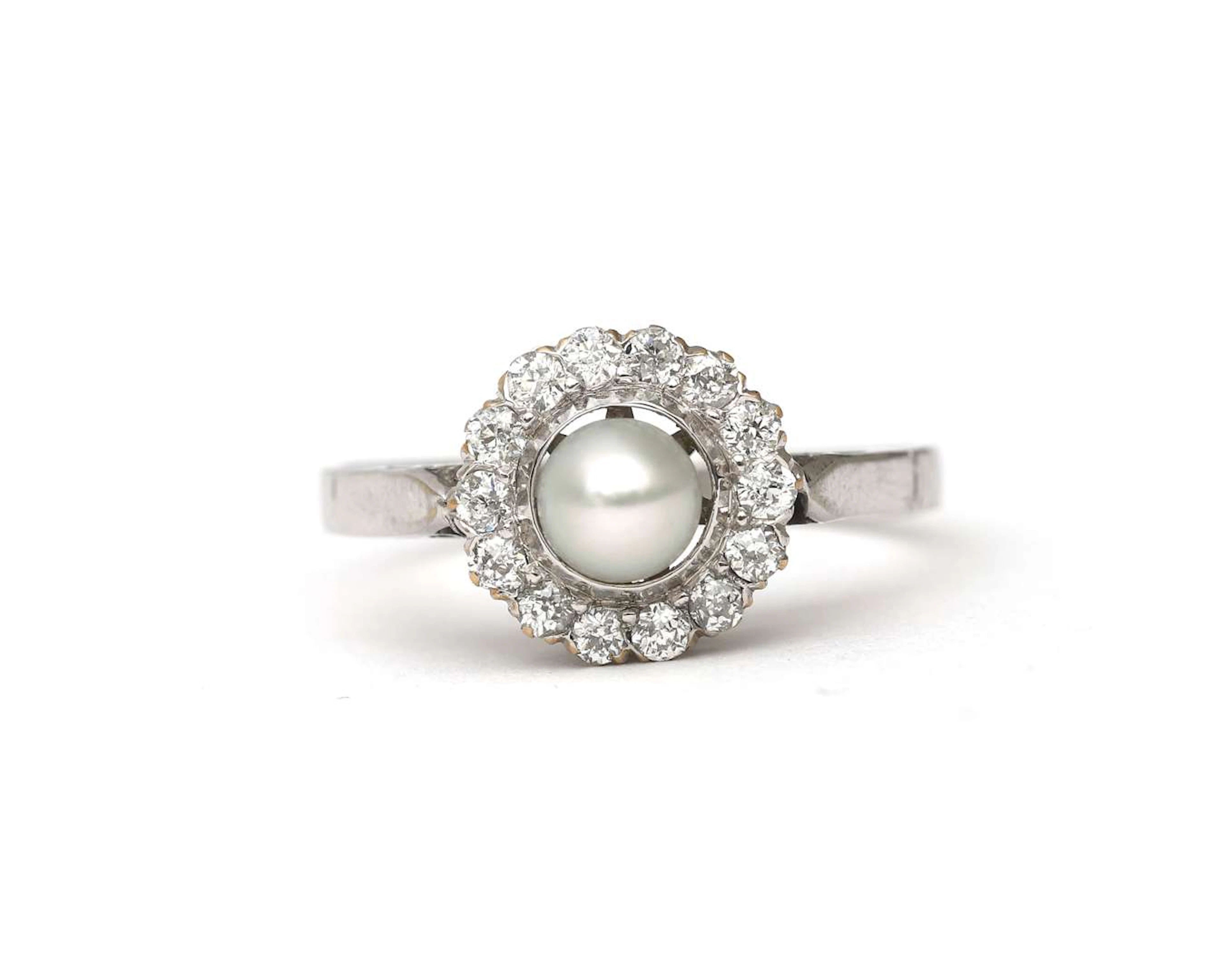 A 14k white gold ring set with a cultured pearl and a diamond
