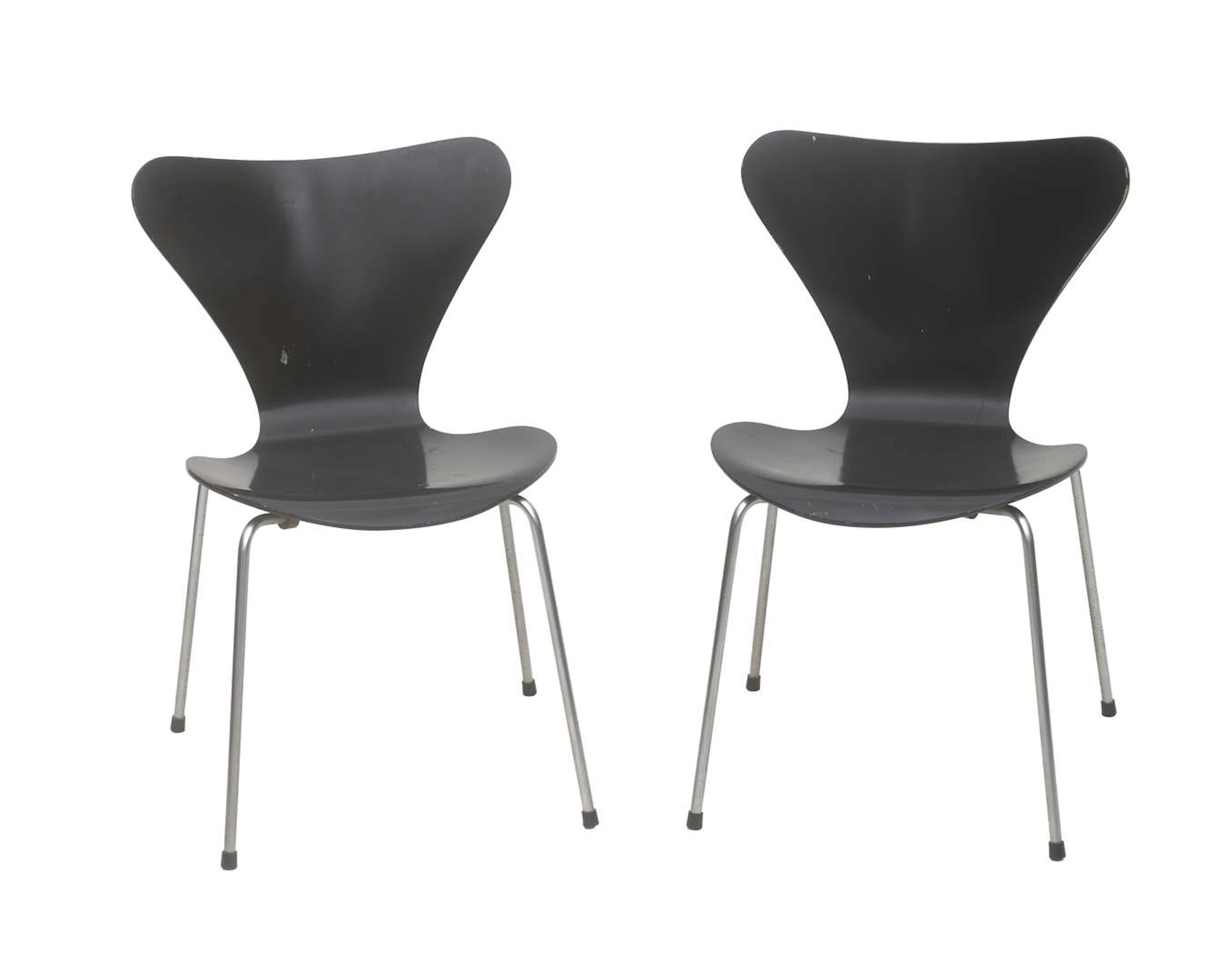 Two black lacquered wooden chairs on metal base, design Arne Jacobsen