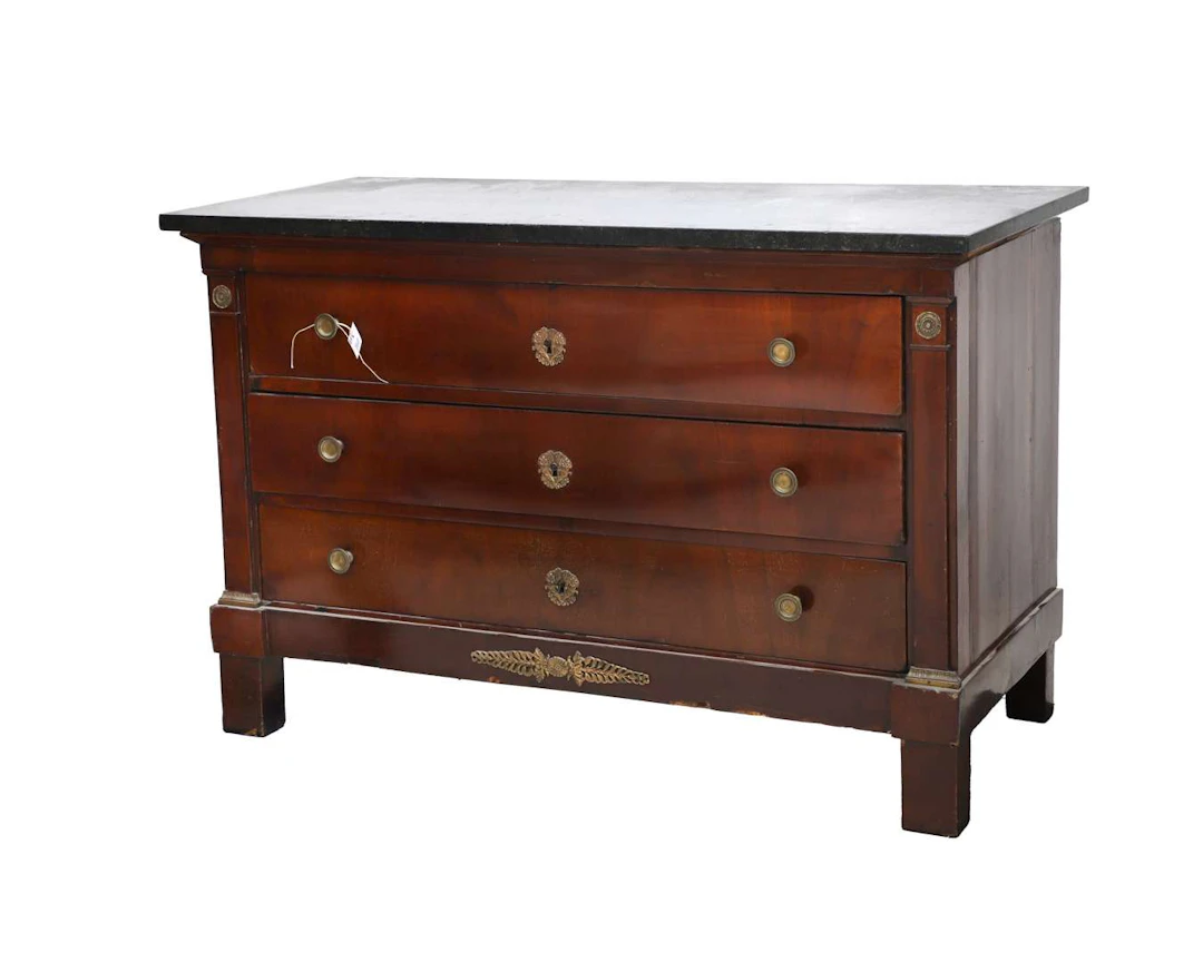 A mahogany chest of drawers with a black marble top. 19th century