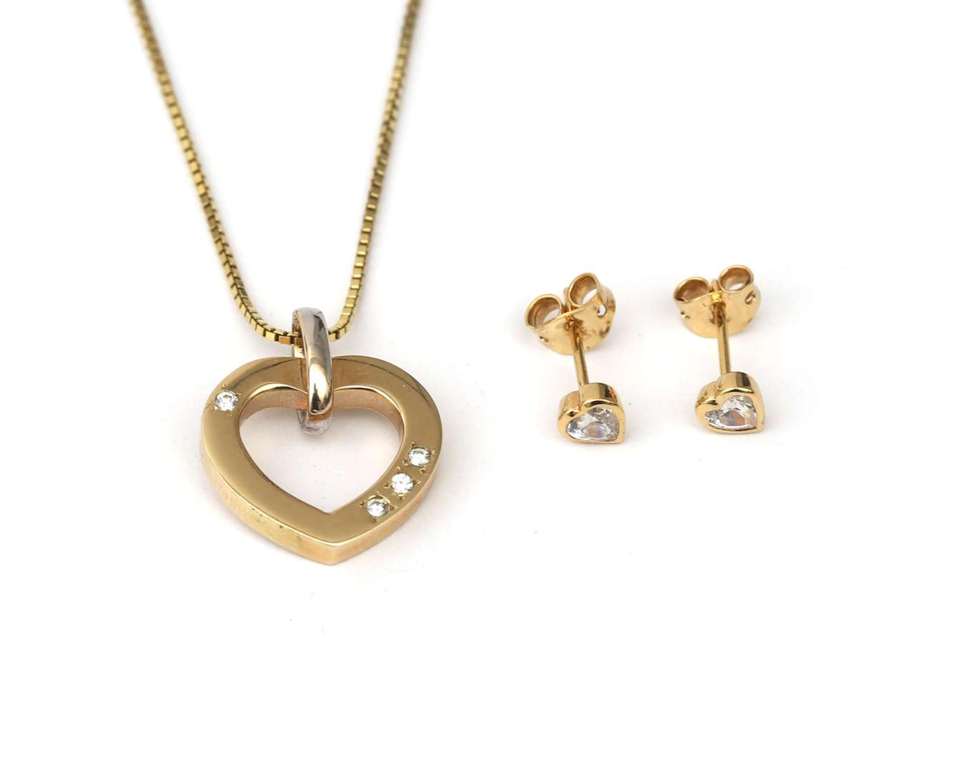 A 14-carat two-tone gold heart pendant with a diamond, on a necklace