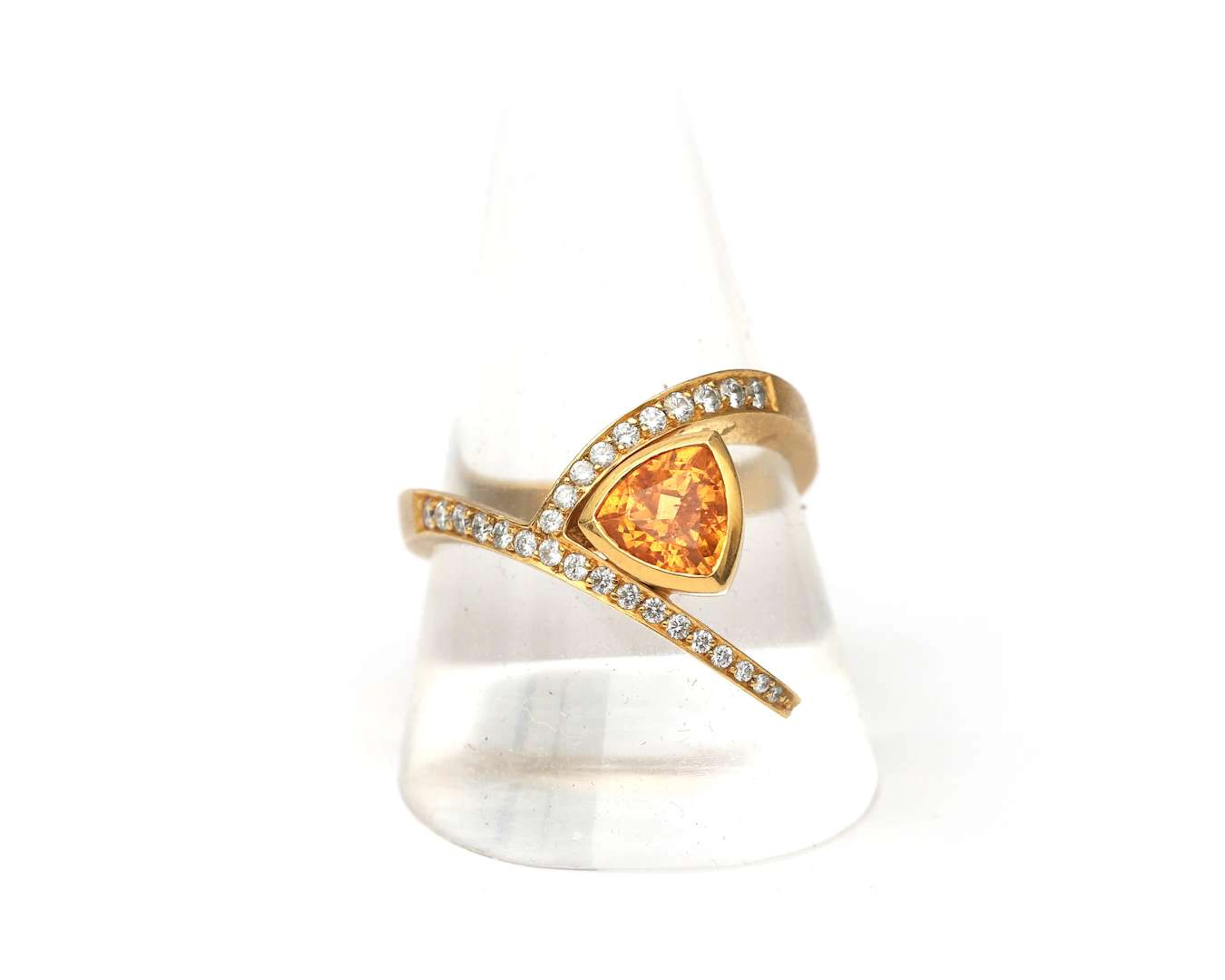 An 18-carat yellow gold ring set with a mandarin garnet and a diamond