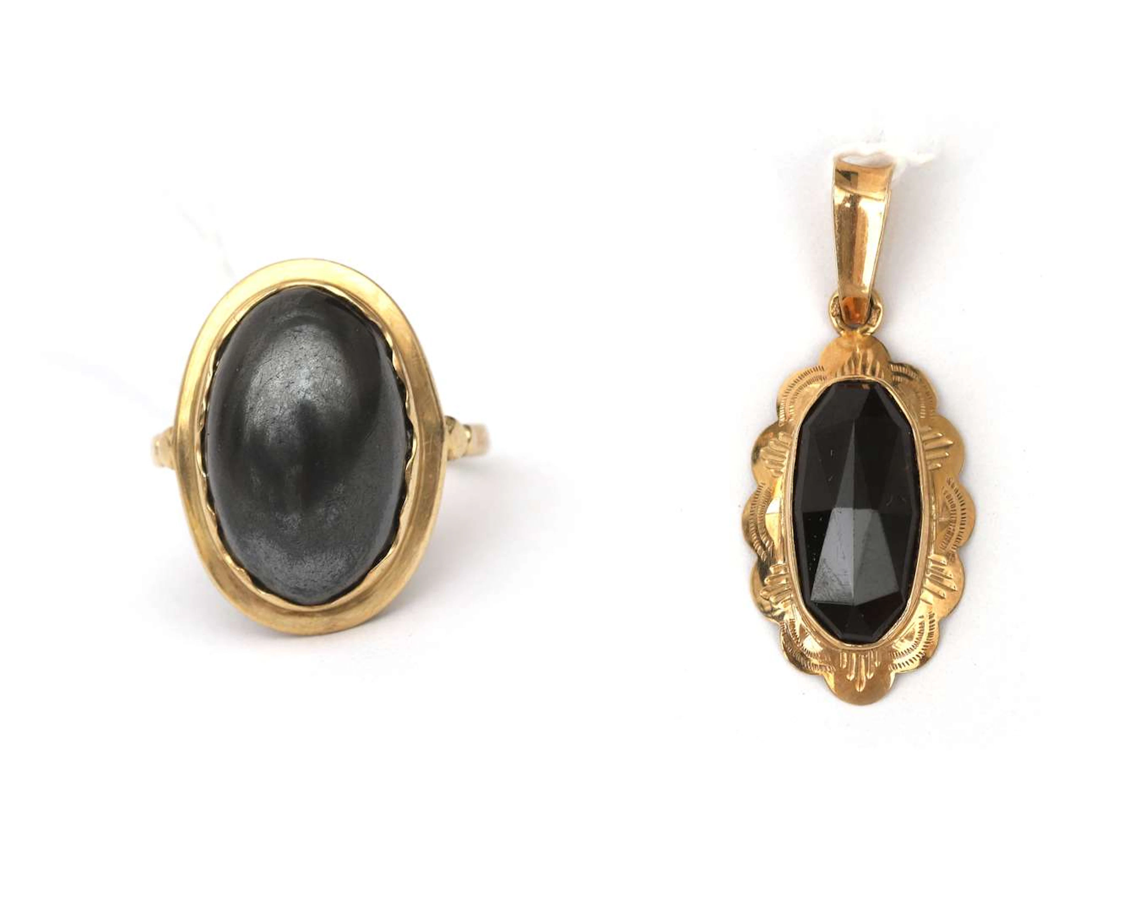 A 14k yellow gold pendant with garnet and a ring set with hematite