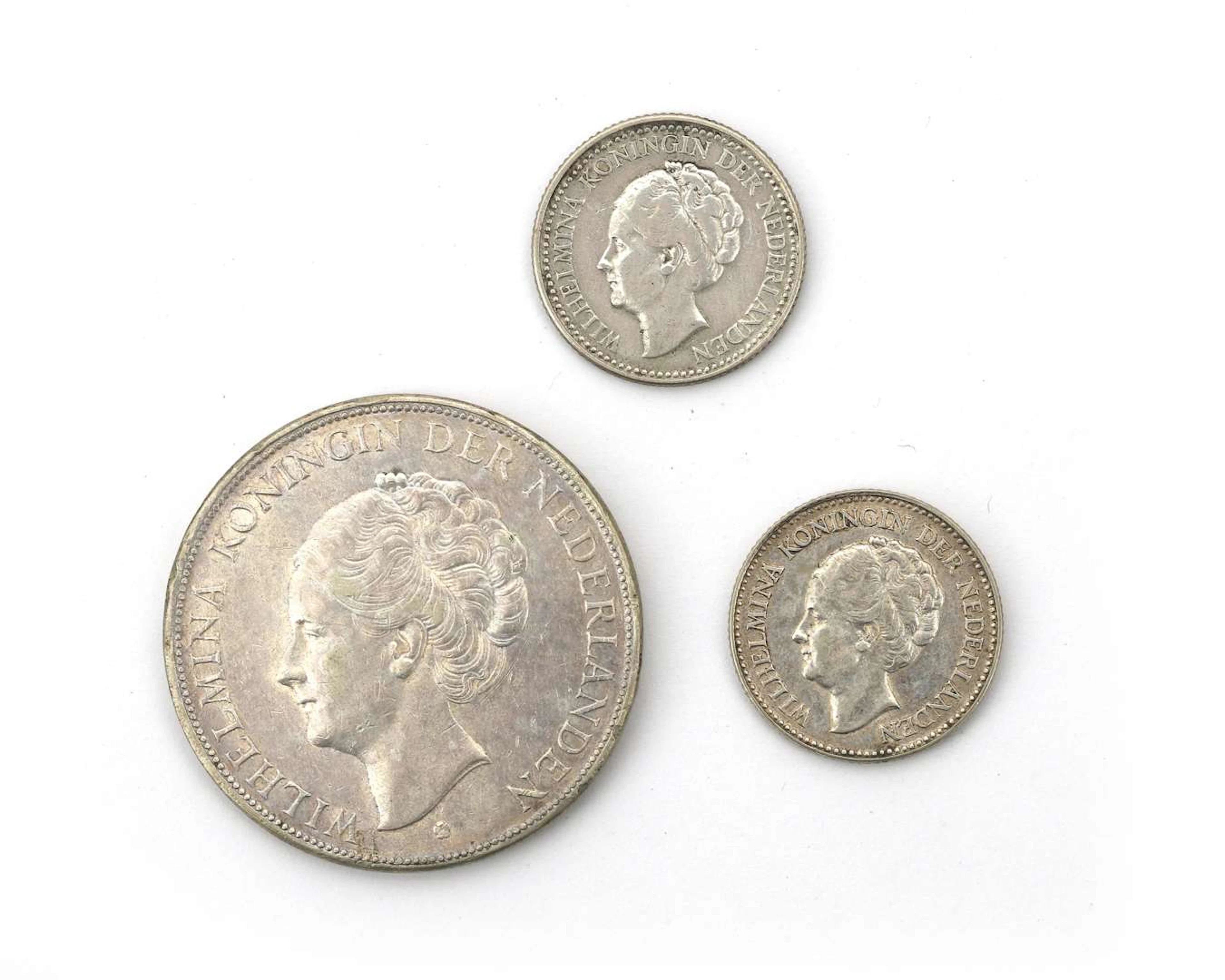 A collection of three silver coins, half guilder and rijksdaalder