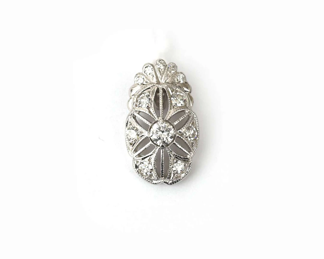 An 18k white gold Belle Époque pendant set with a diamond
