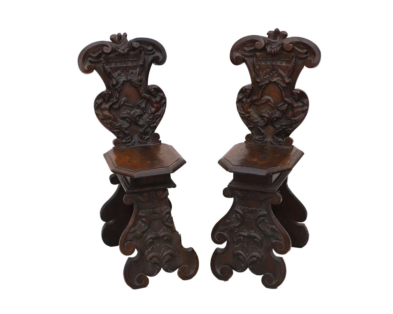 A pair of carved walnut hall chairs or scabellos, Italy, 17th century