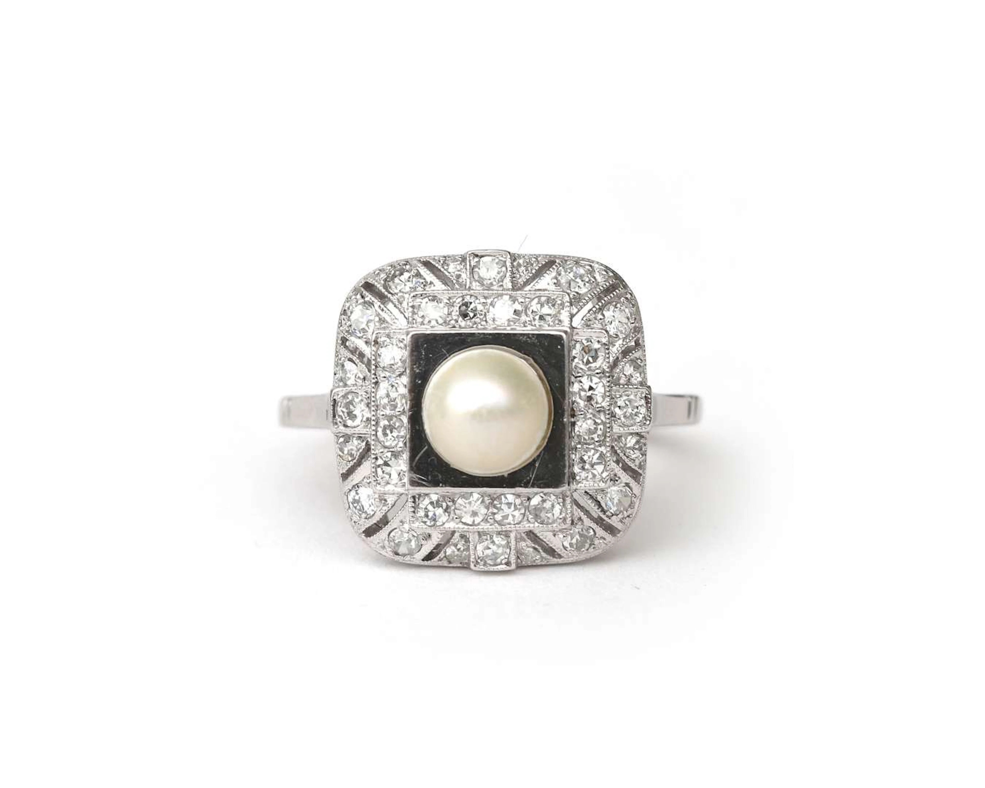 A platinum Art Deco ring with a diamond and a cultured pearl