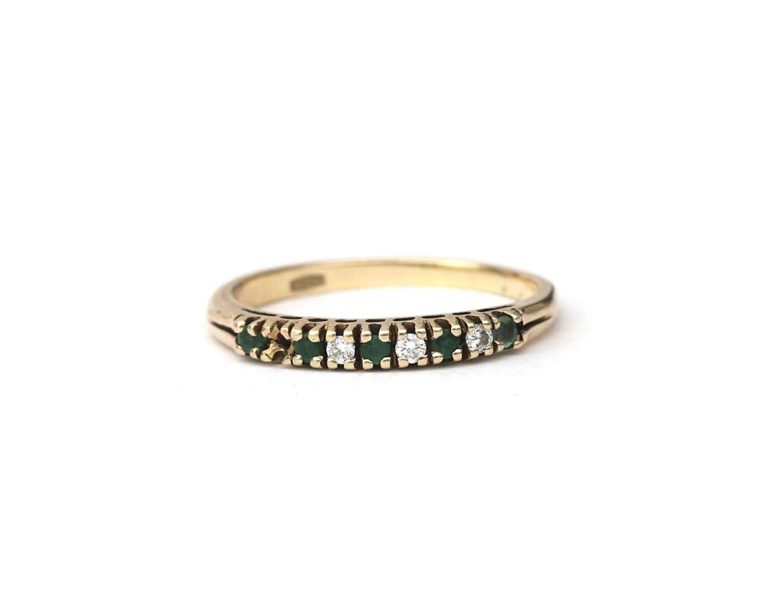 A below legal alloy yellow gold ring set with emeralds and diamonds