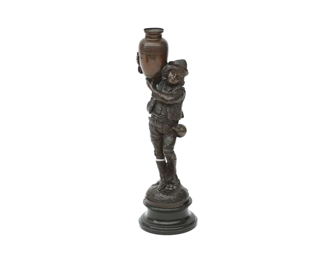 A bronze sculpture of a boy holding a trophy, 20th century