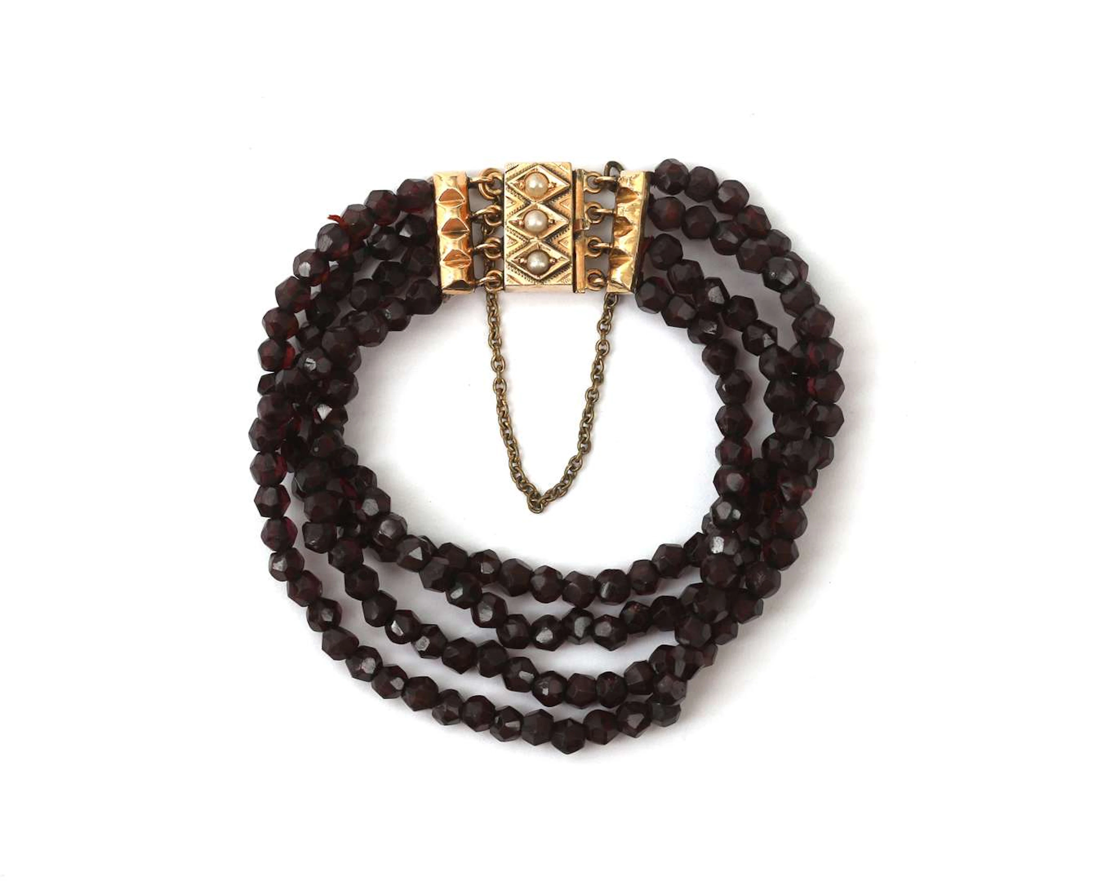 A four-strand garnet bracelet with a 14-carat yellow gold clasp