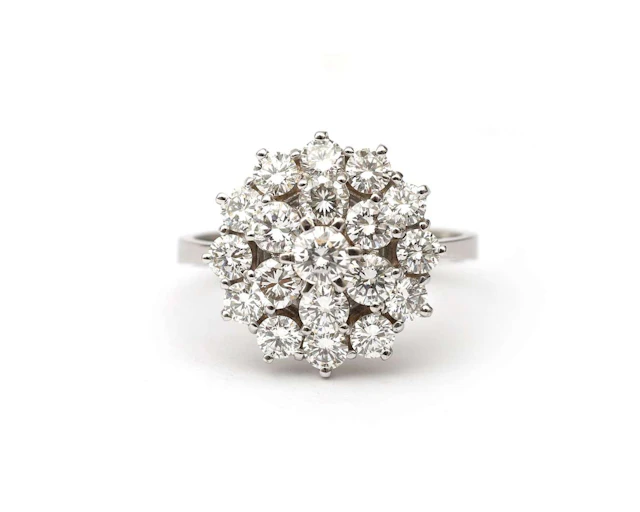 A 14k white gold cluster ring set with a diamond