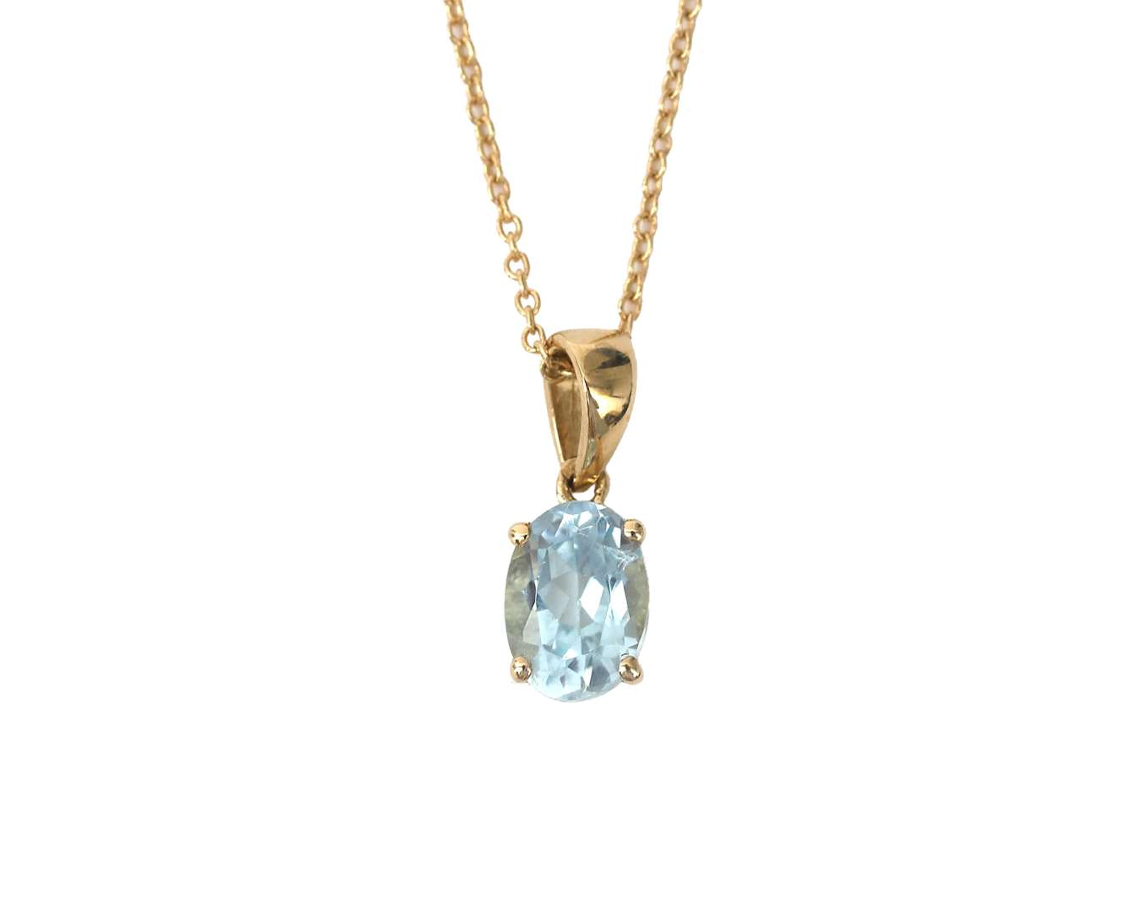 A 14k yellow gold necklace with a pendant set with a blue topaz