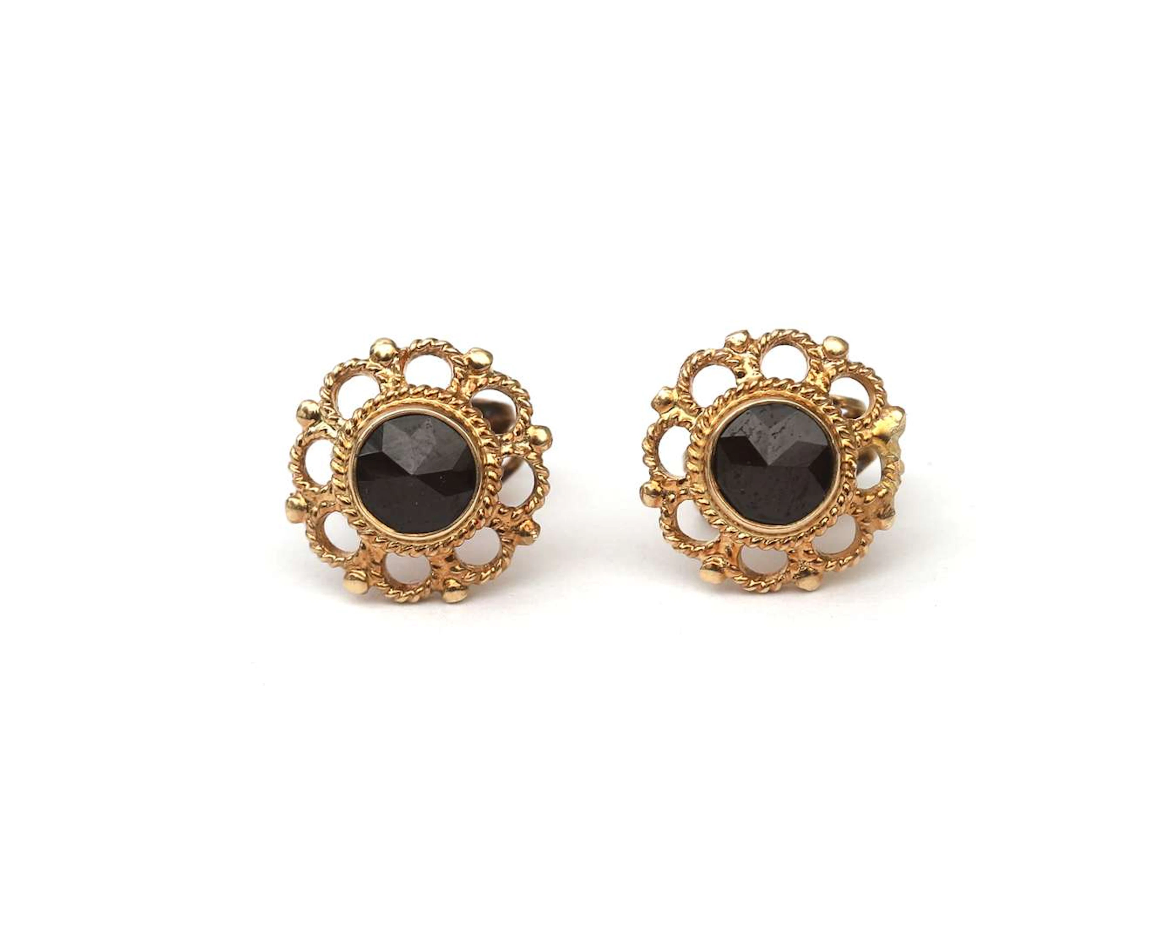 A pair of 14k yellow gold stud earrings with garnets