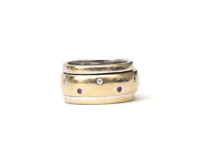 An 18-carat two-tone gold twist ring set with a diamond and a ruby