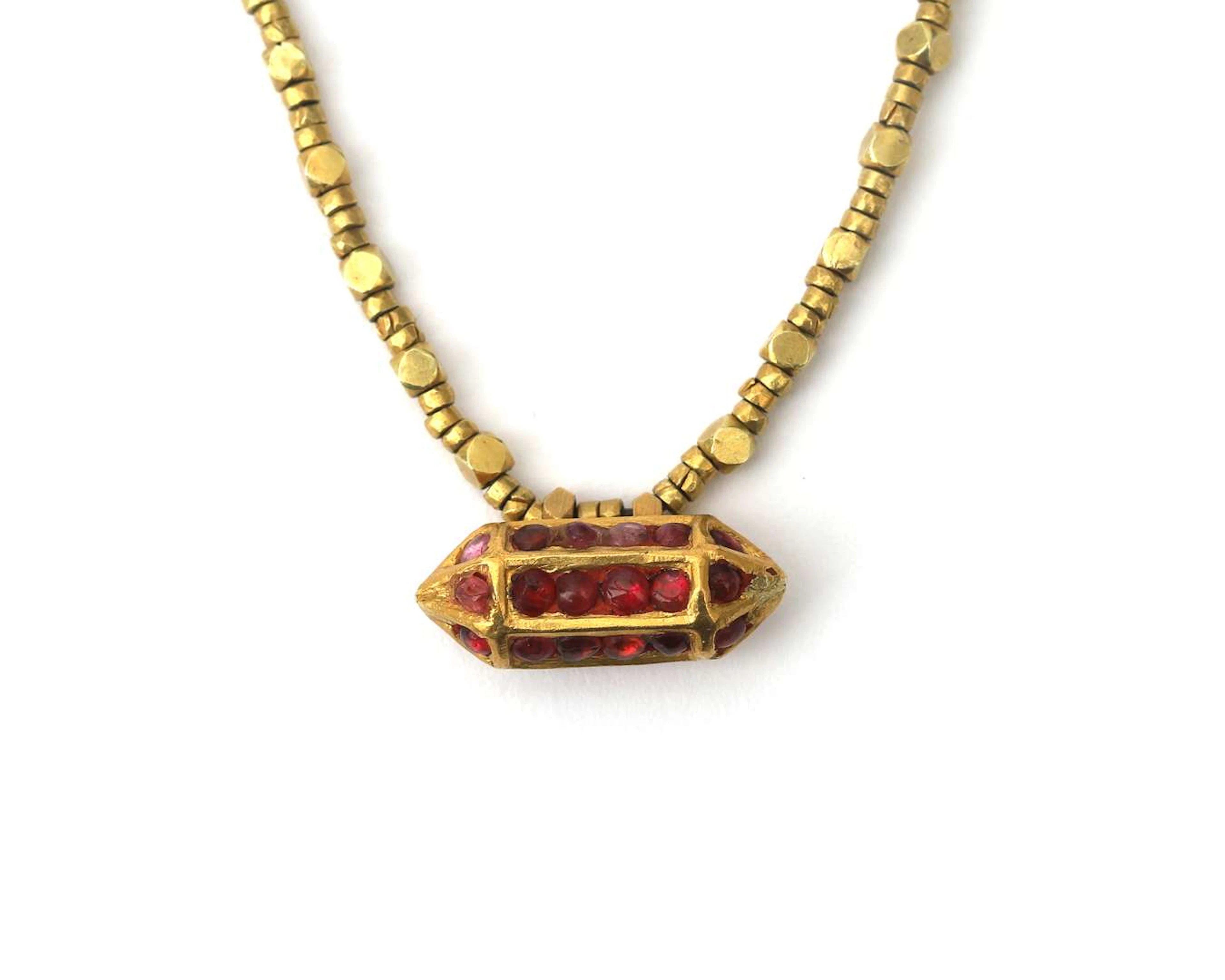 An 18k yellow gold necklace featuring a ‘love brick’ set with a ruby