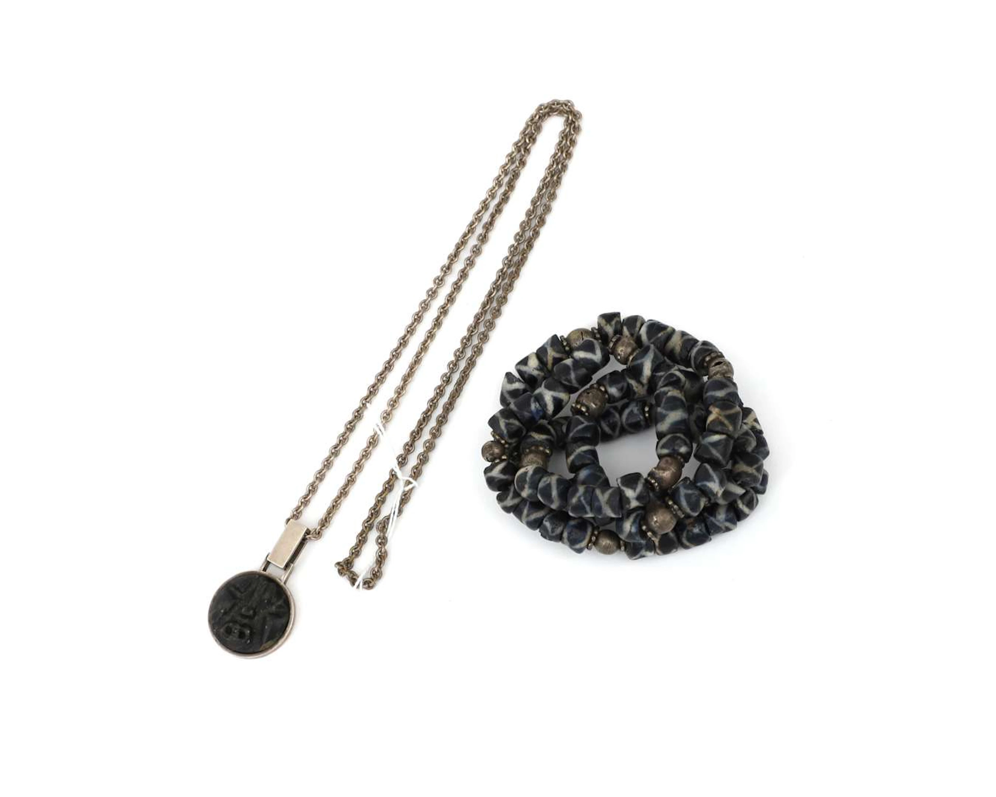 A necklace made from rattlesnake trade beads and a silver necklace