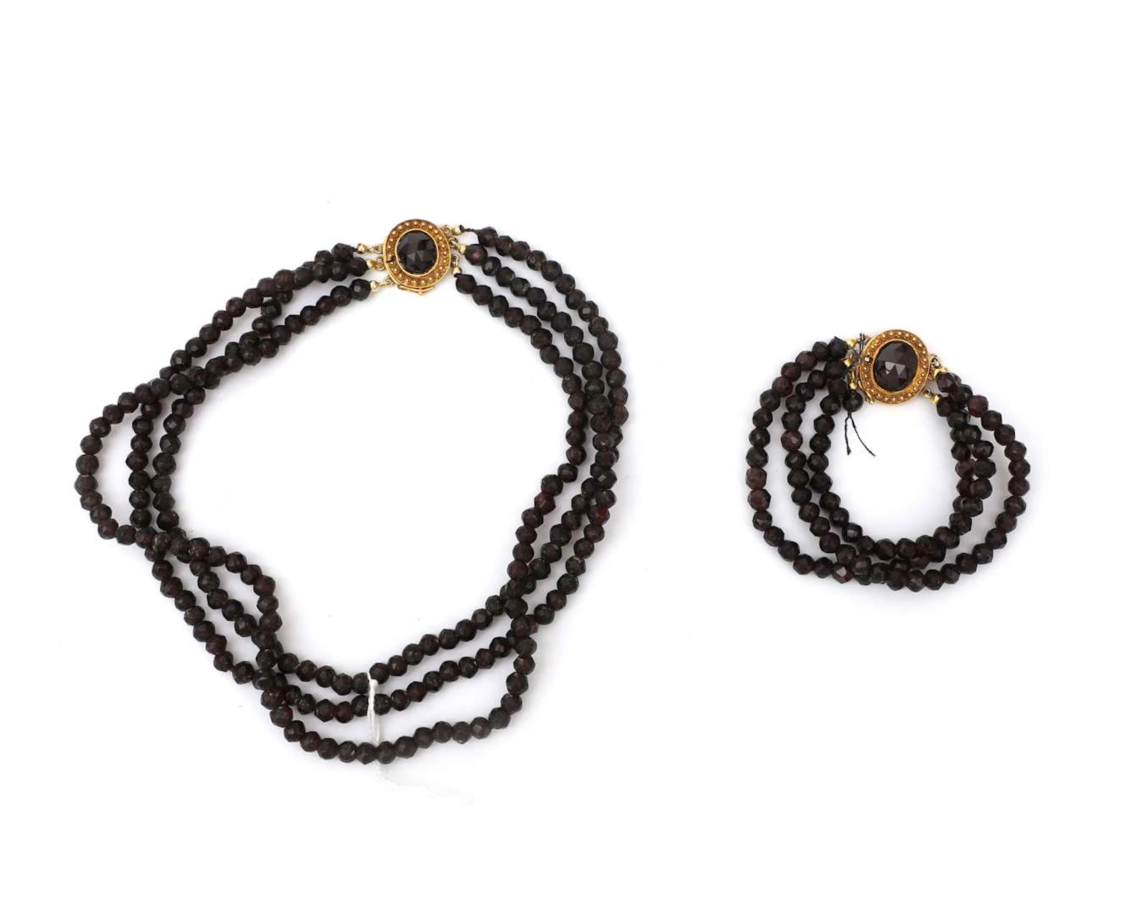 A bracelet and choker with three strands of garnets and 14k yellow gold clasps