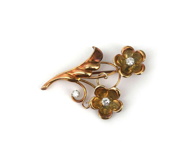 A 14-carat yellow gold floral brooch set with a diamond