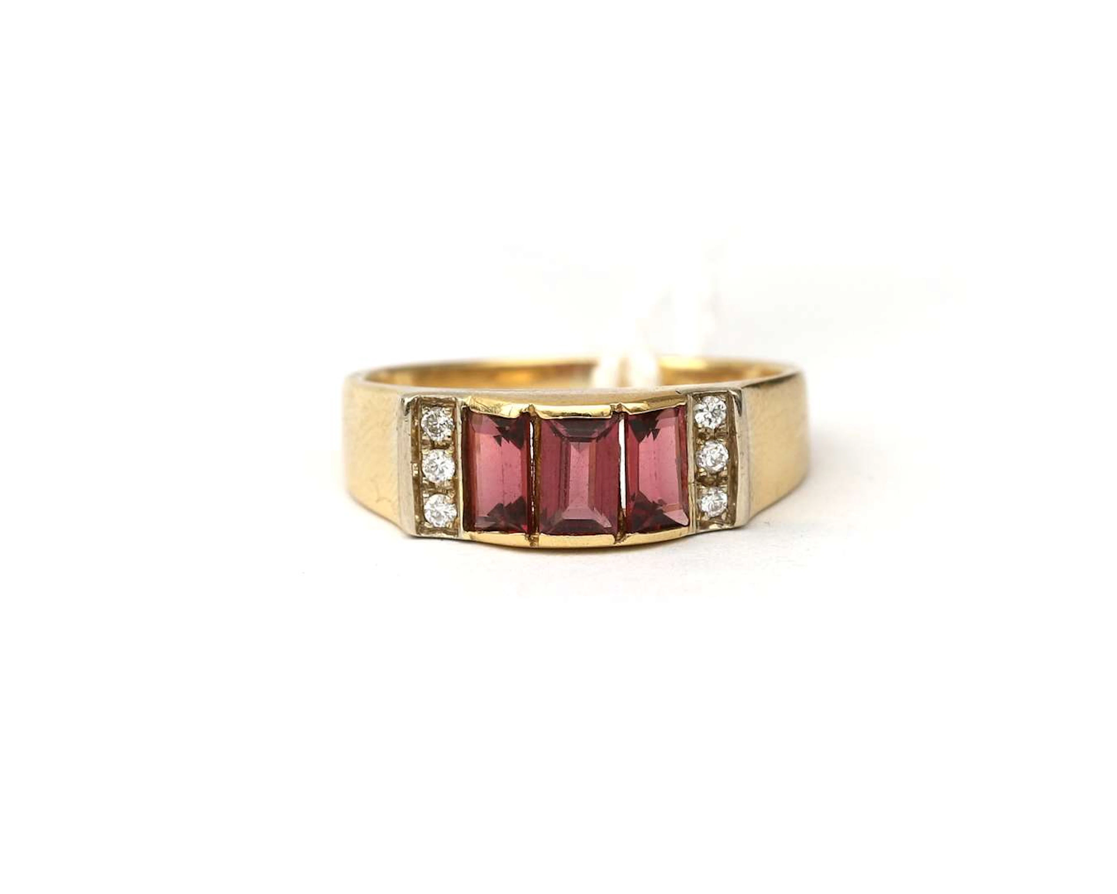 An 18k yellow gold ring set with a garnet and a diamond