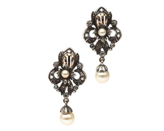 A pair of 18k yellow gold stud earrings with silver settings, featuring