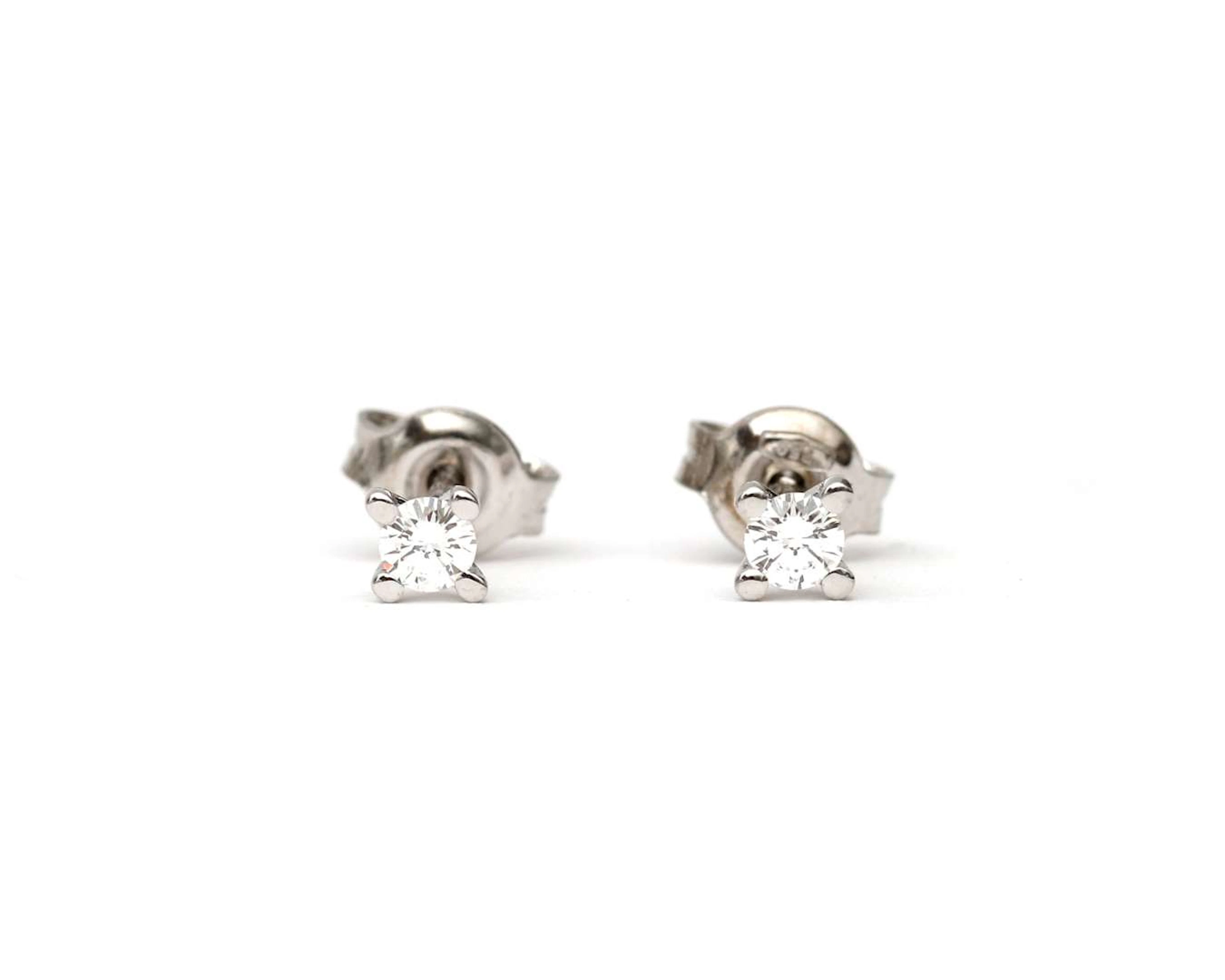 A pair of 18k white gold solitaire diamond stud earrings