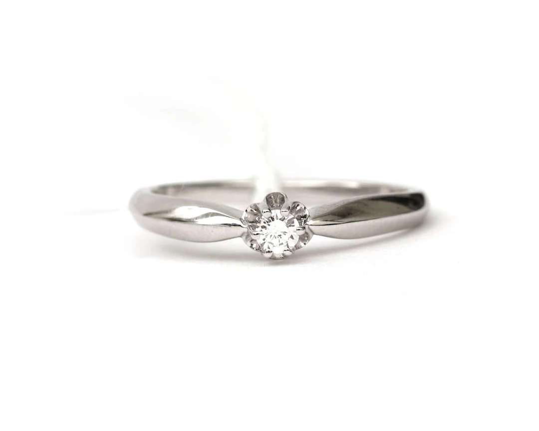 A 14k white gold solitaire ring with a diamond