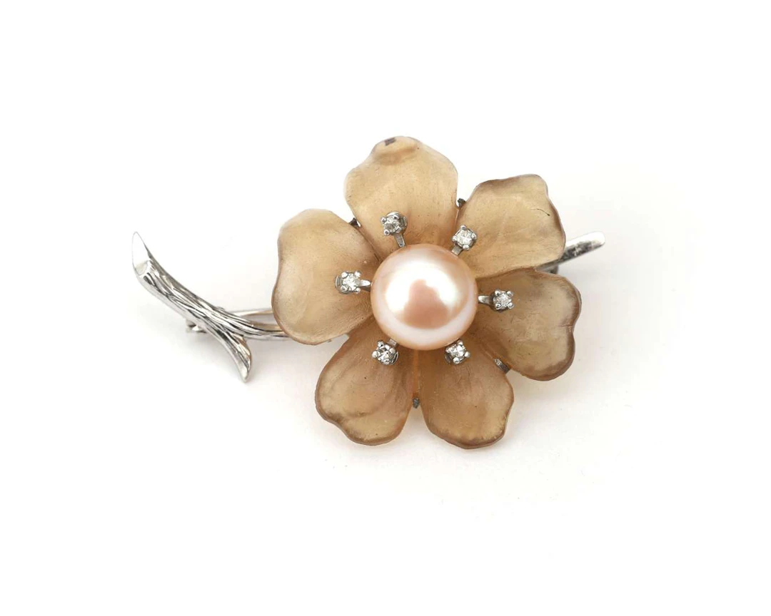 A 14k white gold flower brooch with a pale pink pearl and diamond